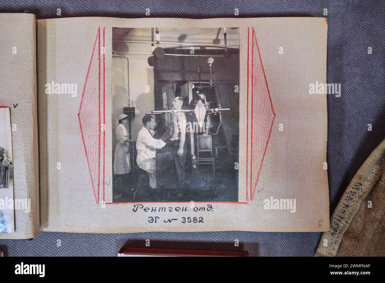 An old B&W photograph in an album, showing a sick patient getting an old film X-Ray. At the Almaty Museum of Local History in Almaty, Kazakhstan. Stock Photo