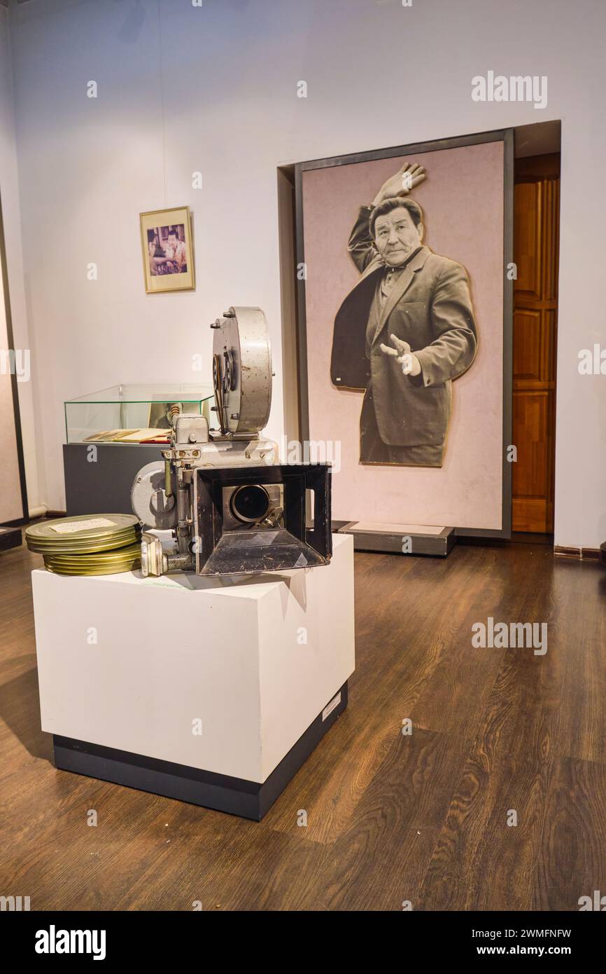 A gallery room featuring items from the local film, movie industry. An old film camera and big picture of a star are on display. At the Almaty Museum Stock Photo