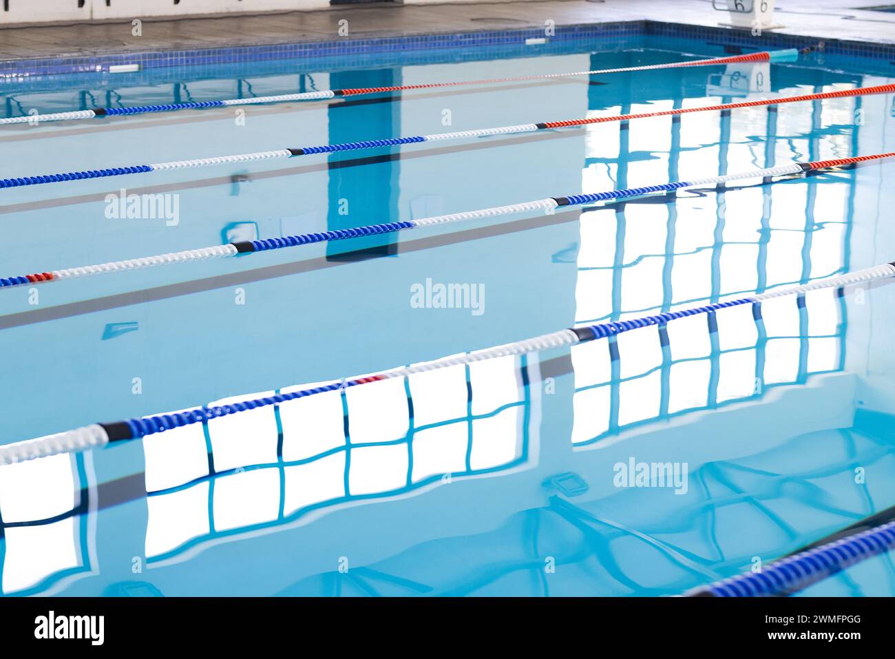 Empty lanes in a serene indoor swimming pool await swimmers Stock Photo