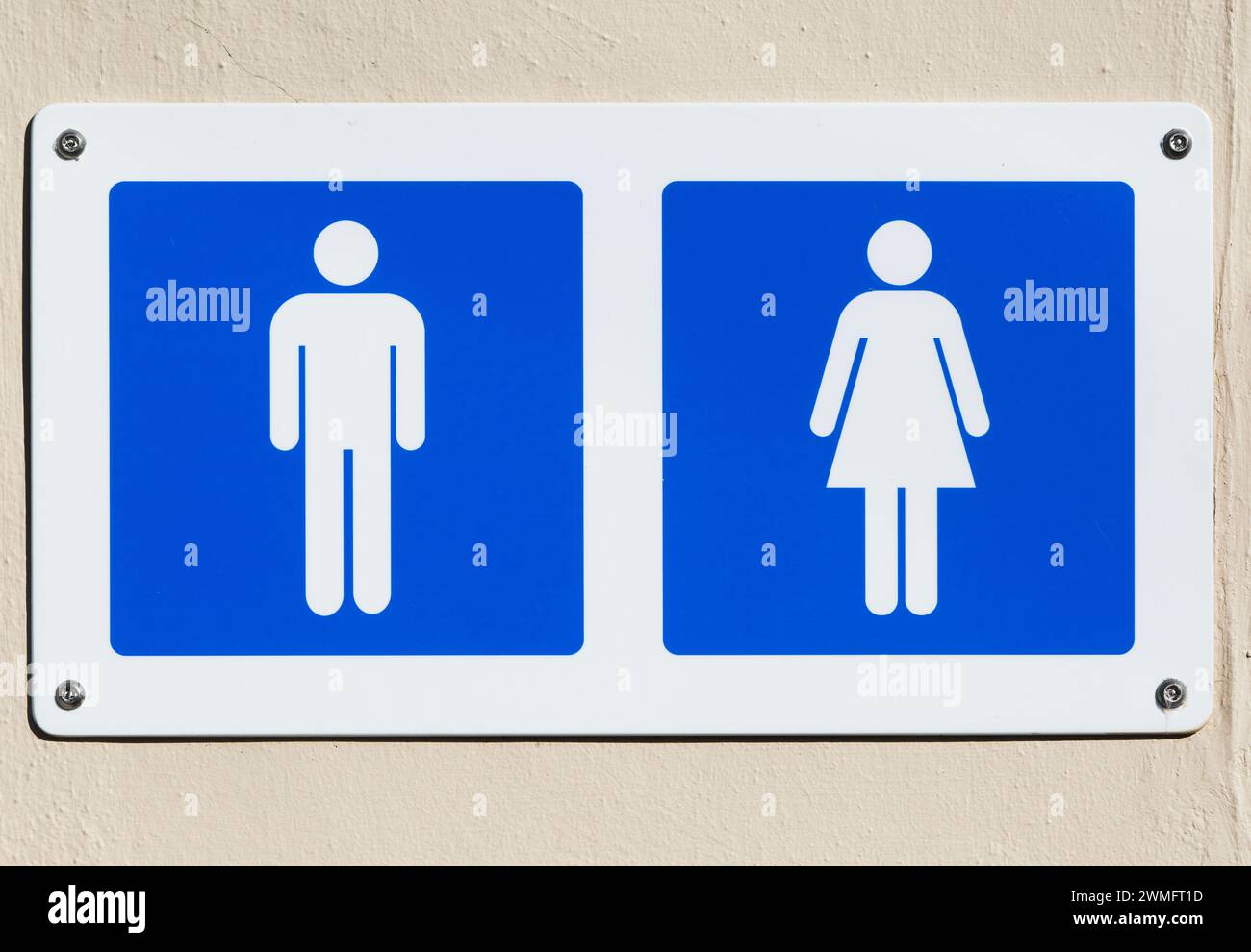 Cut out white male and female figures on blue background, public toilets sign UK Stock Photo