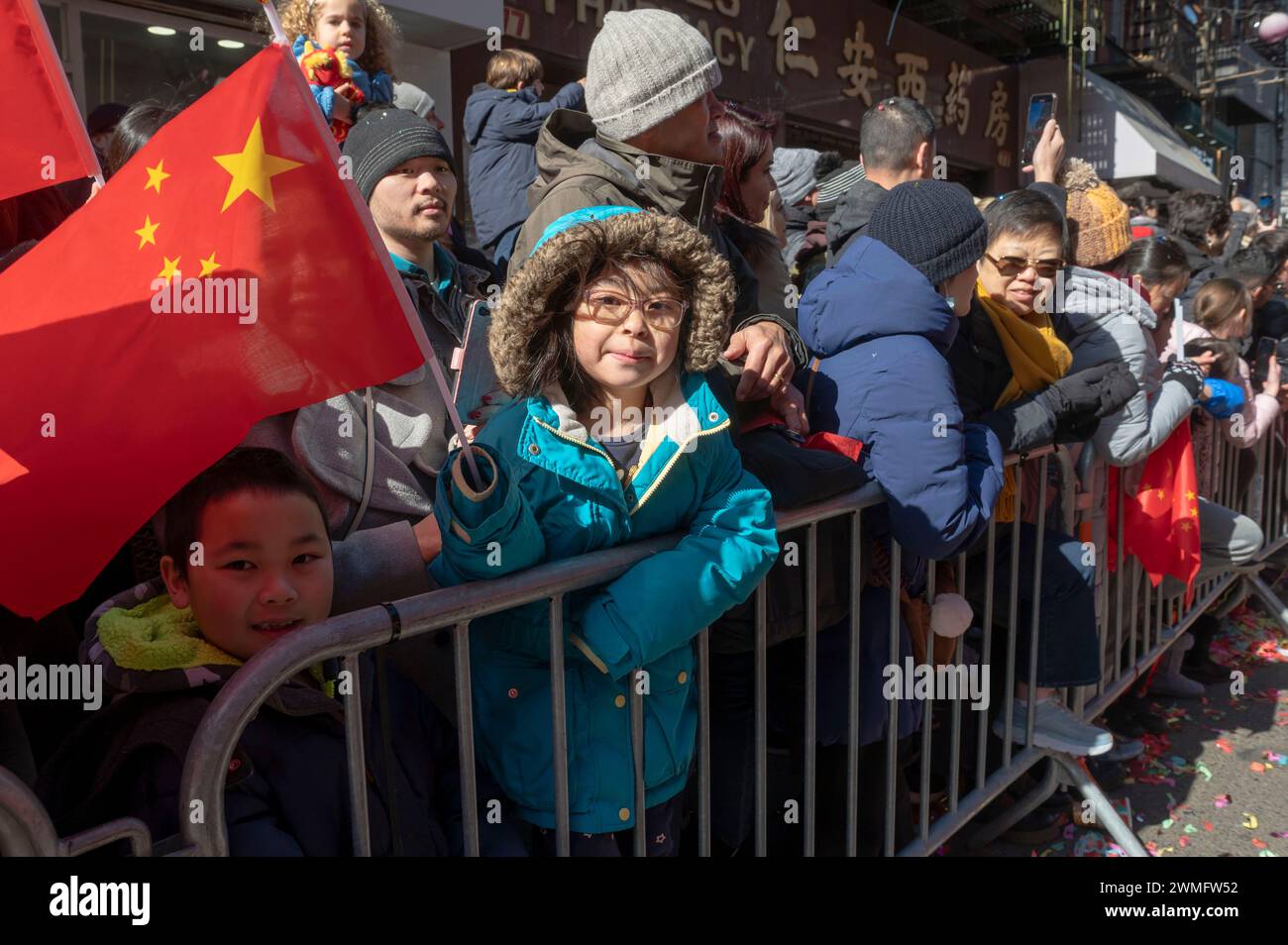 New York, United States. 25th Feb, 2024. Children watch the annual Lunar New Year parade in Chinatown on February 25, 2024 in New York City. People gathered to enjoy and celebrate the 26th annual Lunar New Year parade, commemorating the end of the 15 days honoring the first new moon on the lunar calendar. 2024 is the 'Year of the Dragon.' Credit: SOPA Images Limited/Alamy Live News Stock Photo