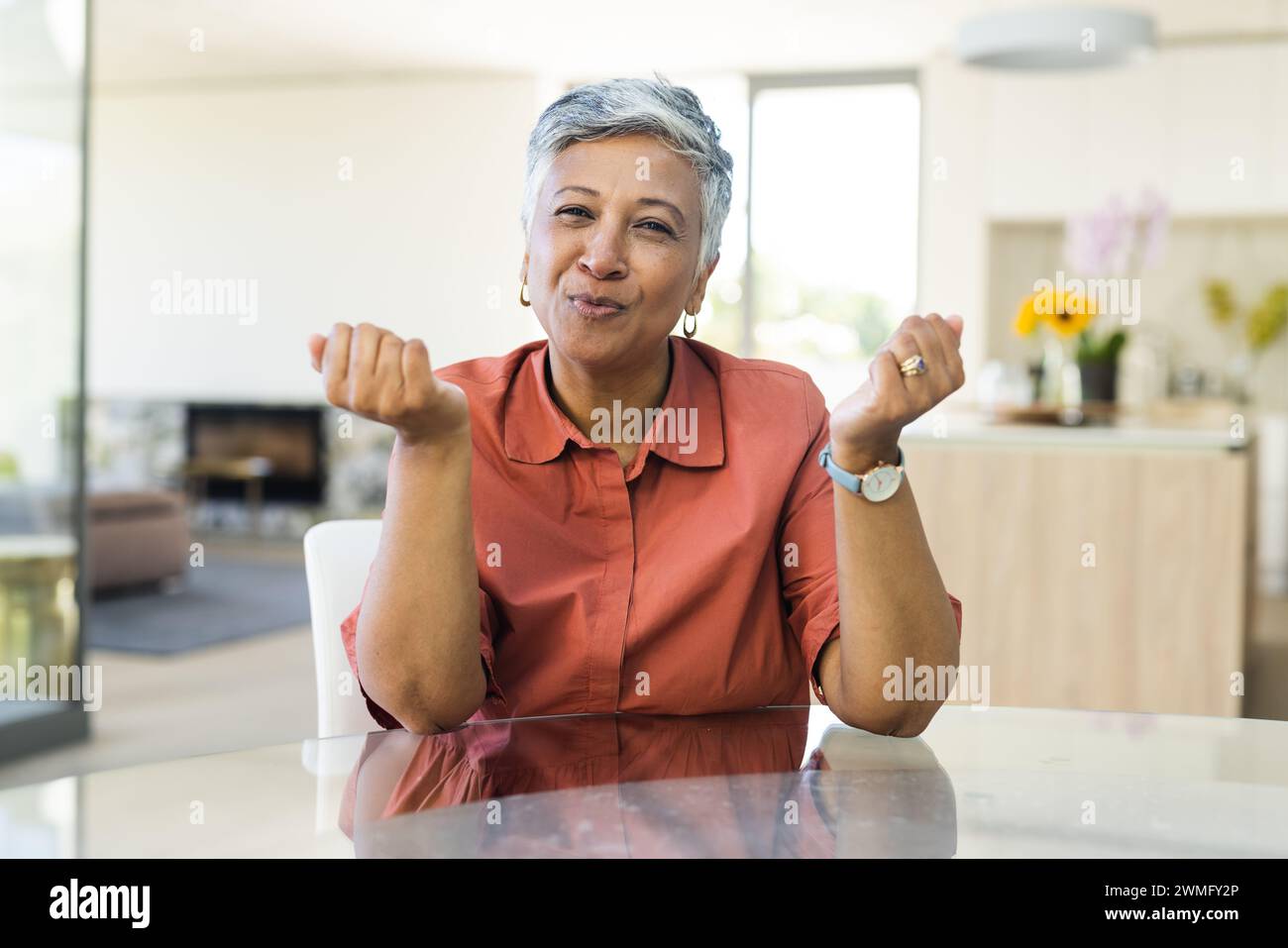 Senior biracial woman makes a playful gesture at home Stock Photo