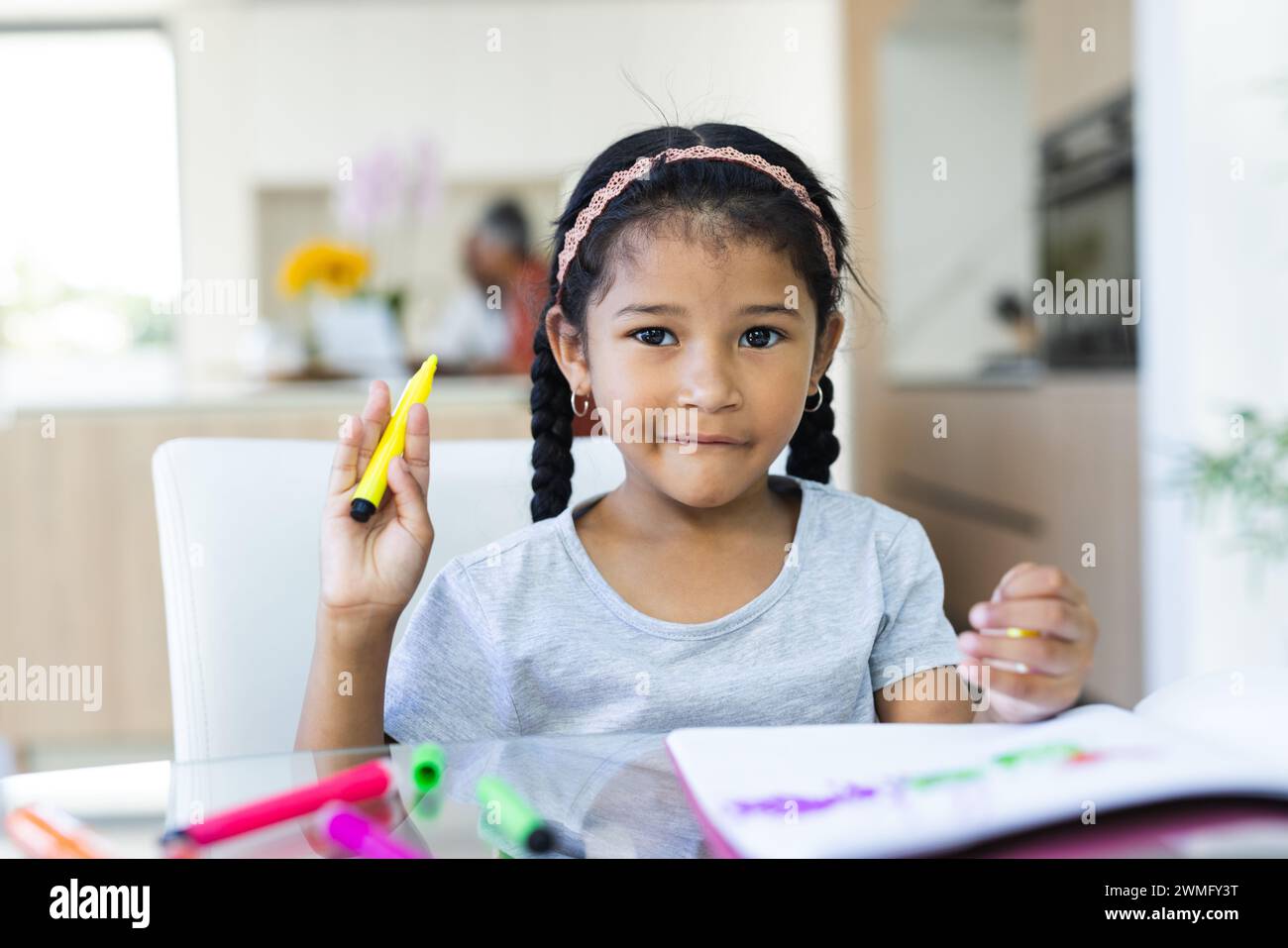 Biracial girl engaged in coloring at home Stock Photo - Alamy