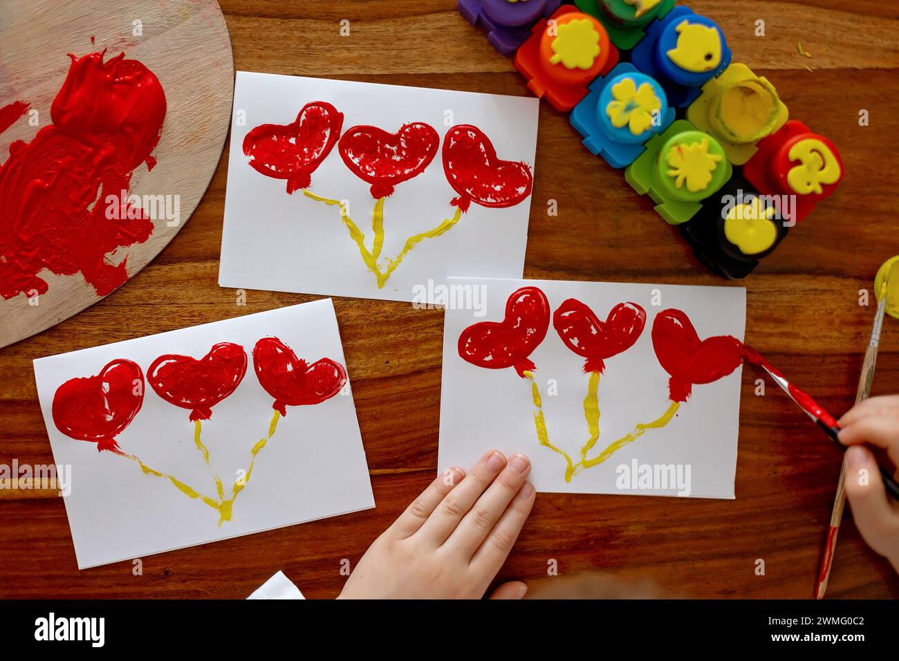 Child, making creative art picture with hearts for Valentine Stock Photo