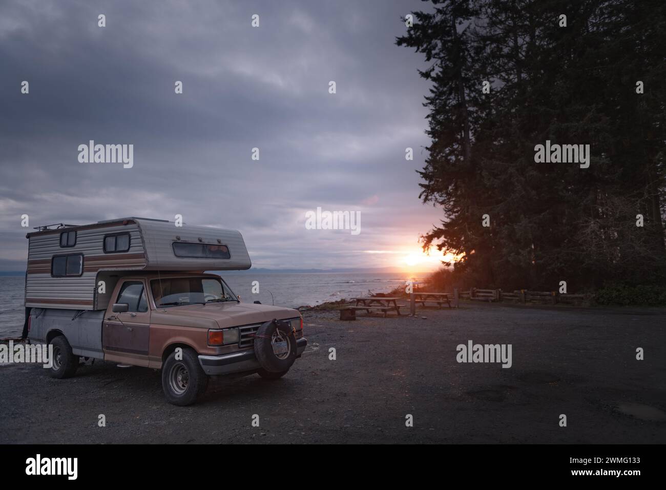Vintage camper truck parked in front of ocean at sunset Stock Photo - Alamy