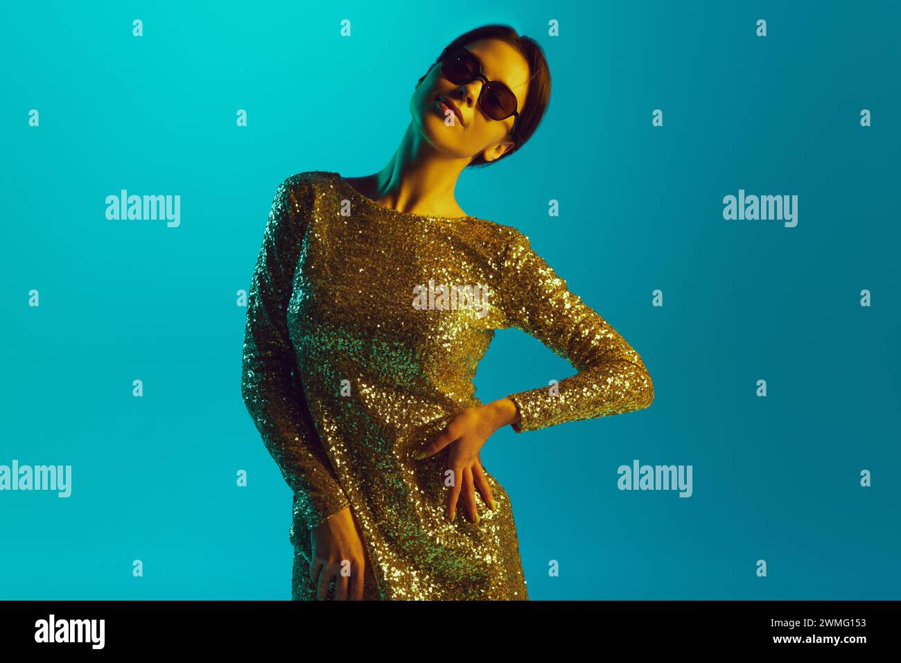 Portrait of beautiful young woman wearing festive dress and sunglasses ...
