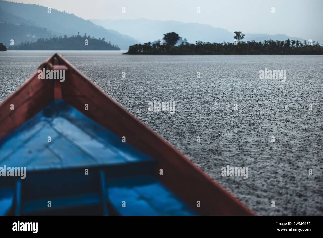 A boat navigates Lake Kivu, Rwanda in a heavy rain downpour Stock Photo ...