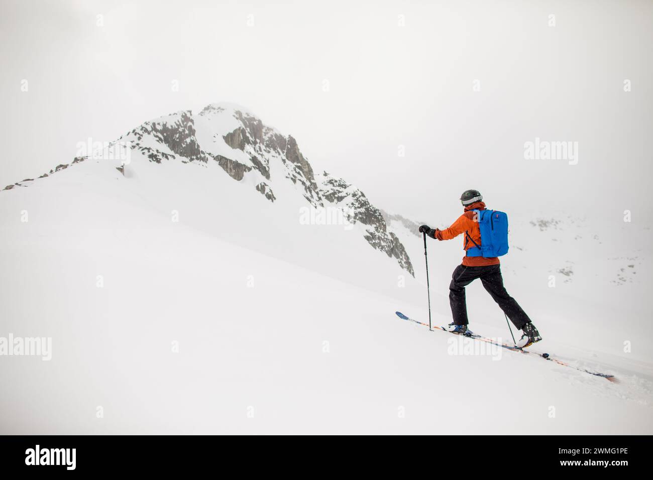 side view of backcountry skier approaches mountain summit Stock Photo