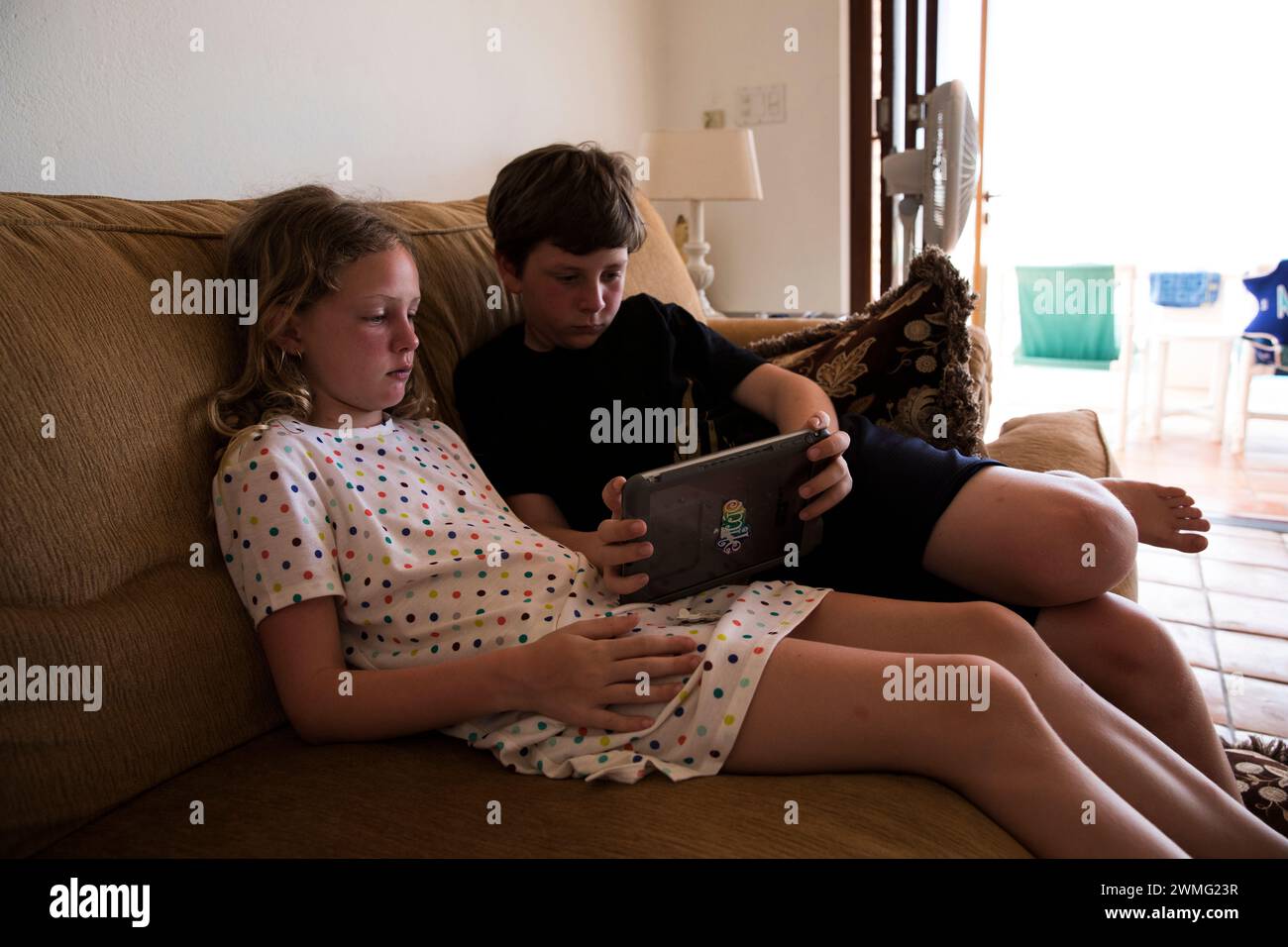 Siblings Watch Single Ipad Together On Vacation Stock Photo - Alamy