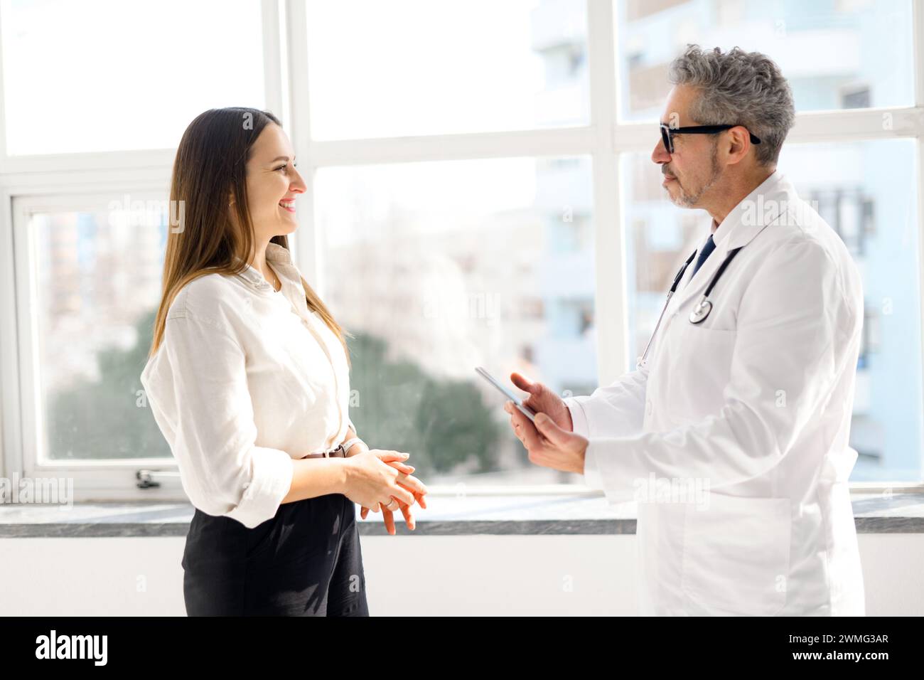 A seasoned doctor with grey hair engaging in a friendly conversation ...