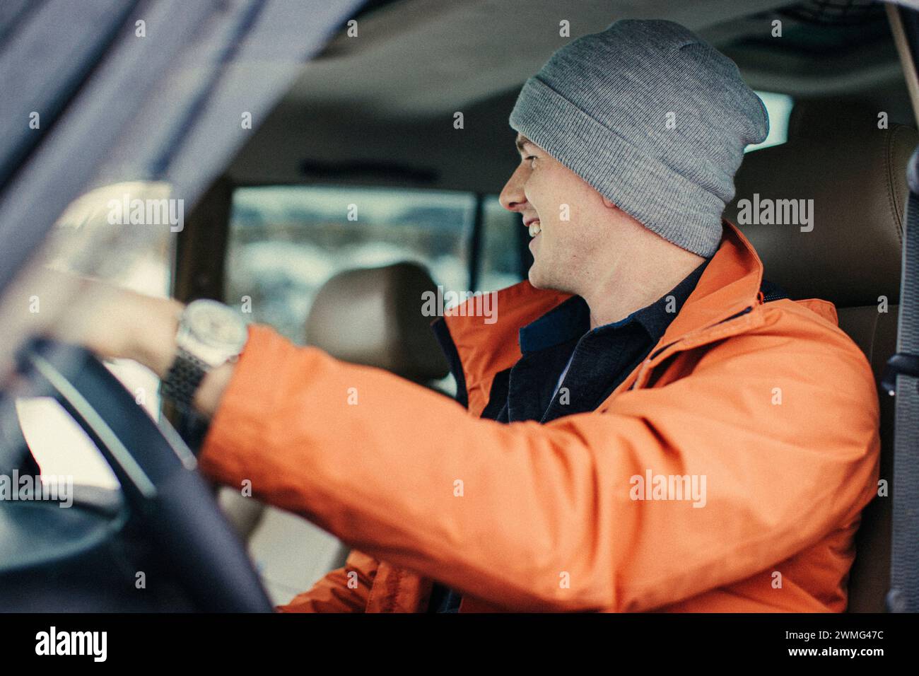 A Caucasian young male smiles while sitting inside a vehicle. Stock Photo