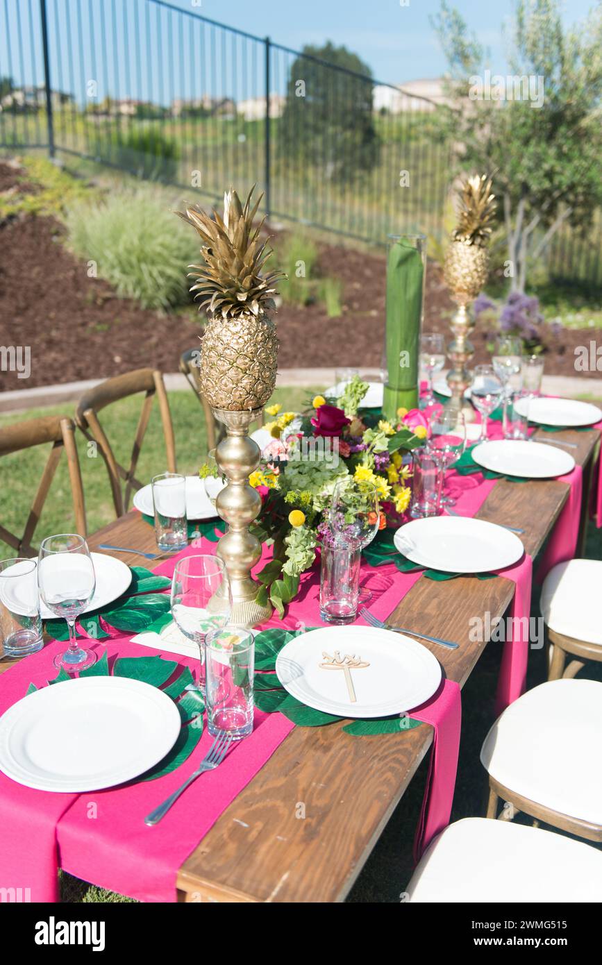 Tropical Theme Table Setting with Pineapples and Flowers Stock Photo