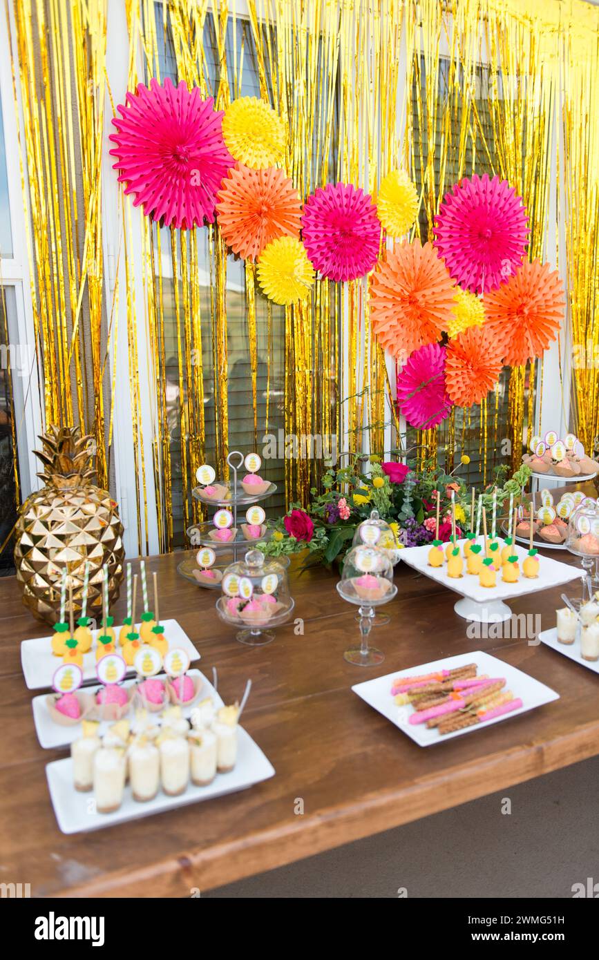 Dessert Table with Pineapple Decorations on a Wooden Table Stock Photo