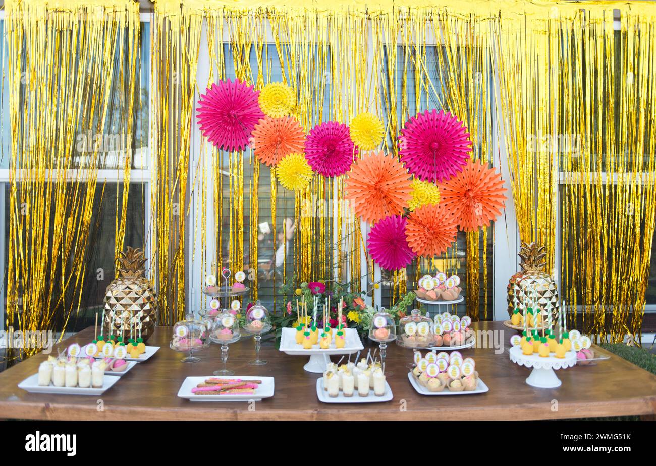 Dessert Table with Pineapple Decorations on a Wooden Table Stock Photo