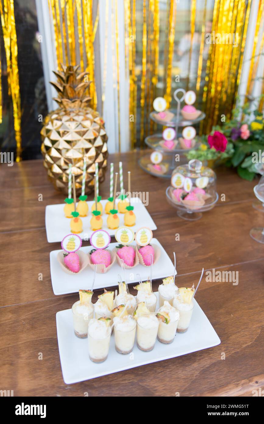Dessert Table with Pineapple Decorations on a Wooden Table Stock Photo