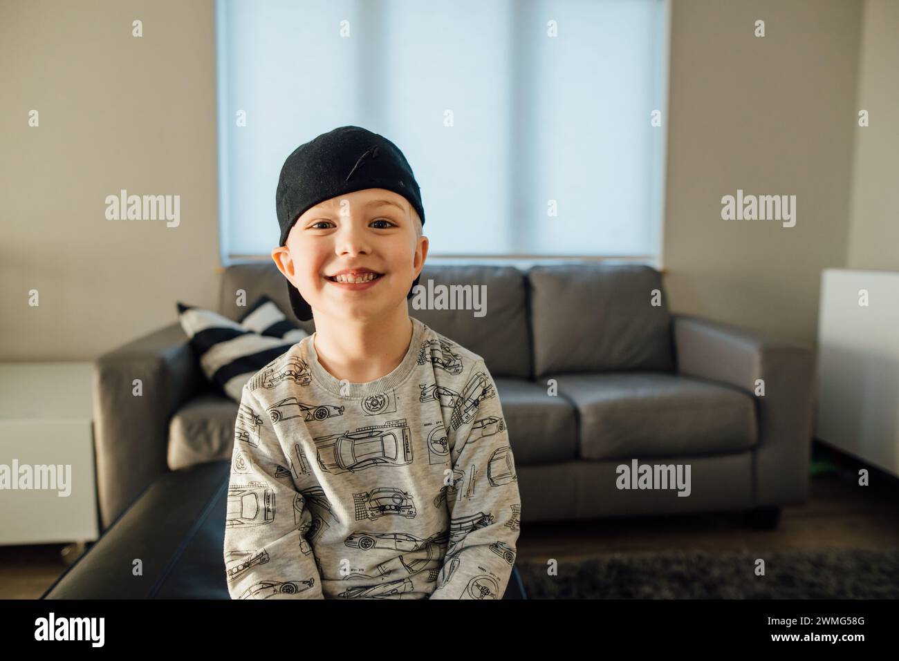 Close up portrait of young boy smiling at camera in living room Stock Photo