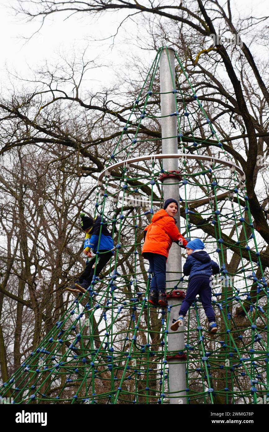 The kids climbing the net amidst trees in Solacki Park. Poznan, Poland Stock Photo