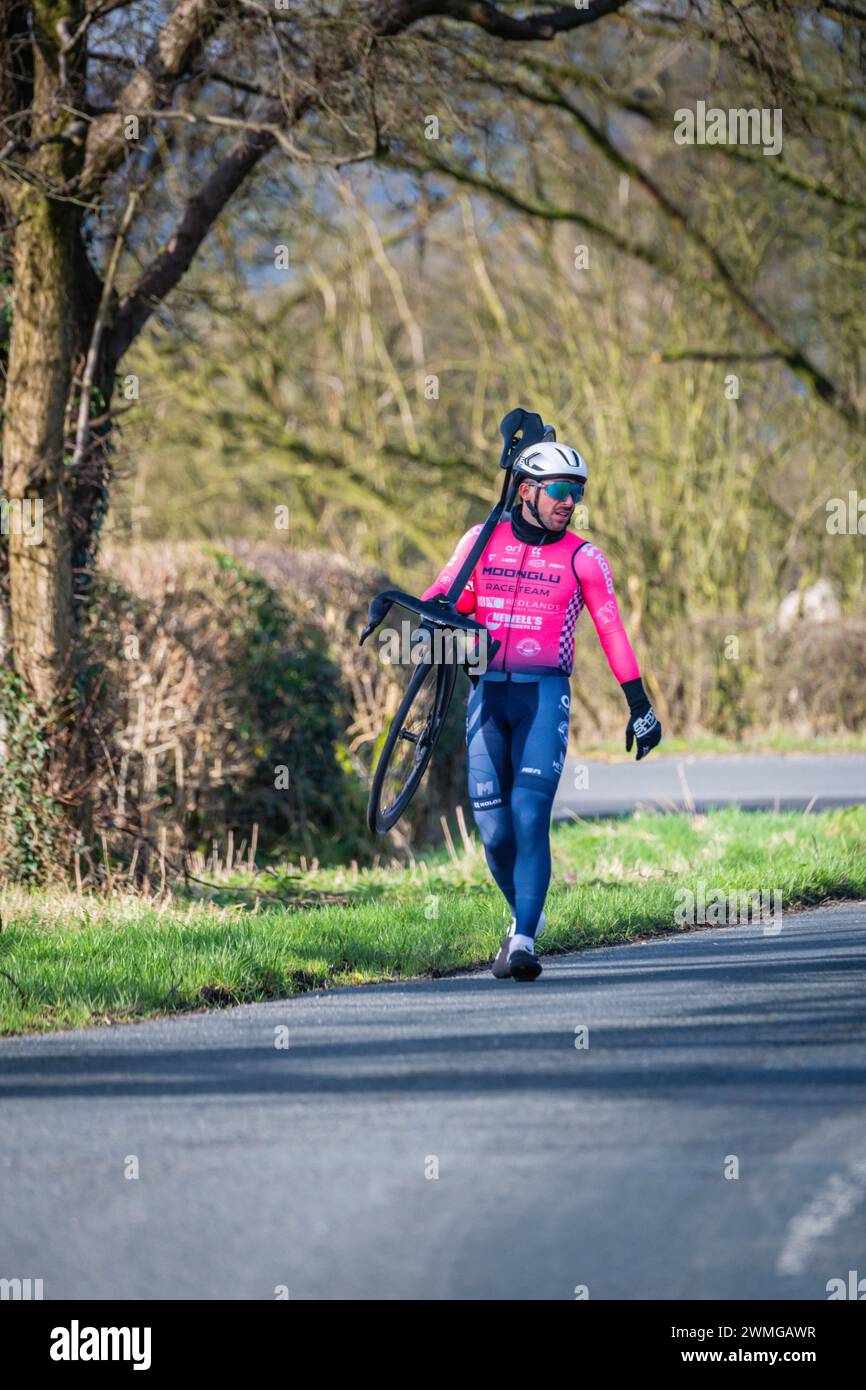 Not everyone gets to finish. A rider from the Clayton Spring Classic walking back to the showers after a double puncture from hitting a pothole. Stock Photo