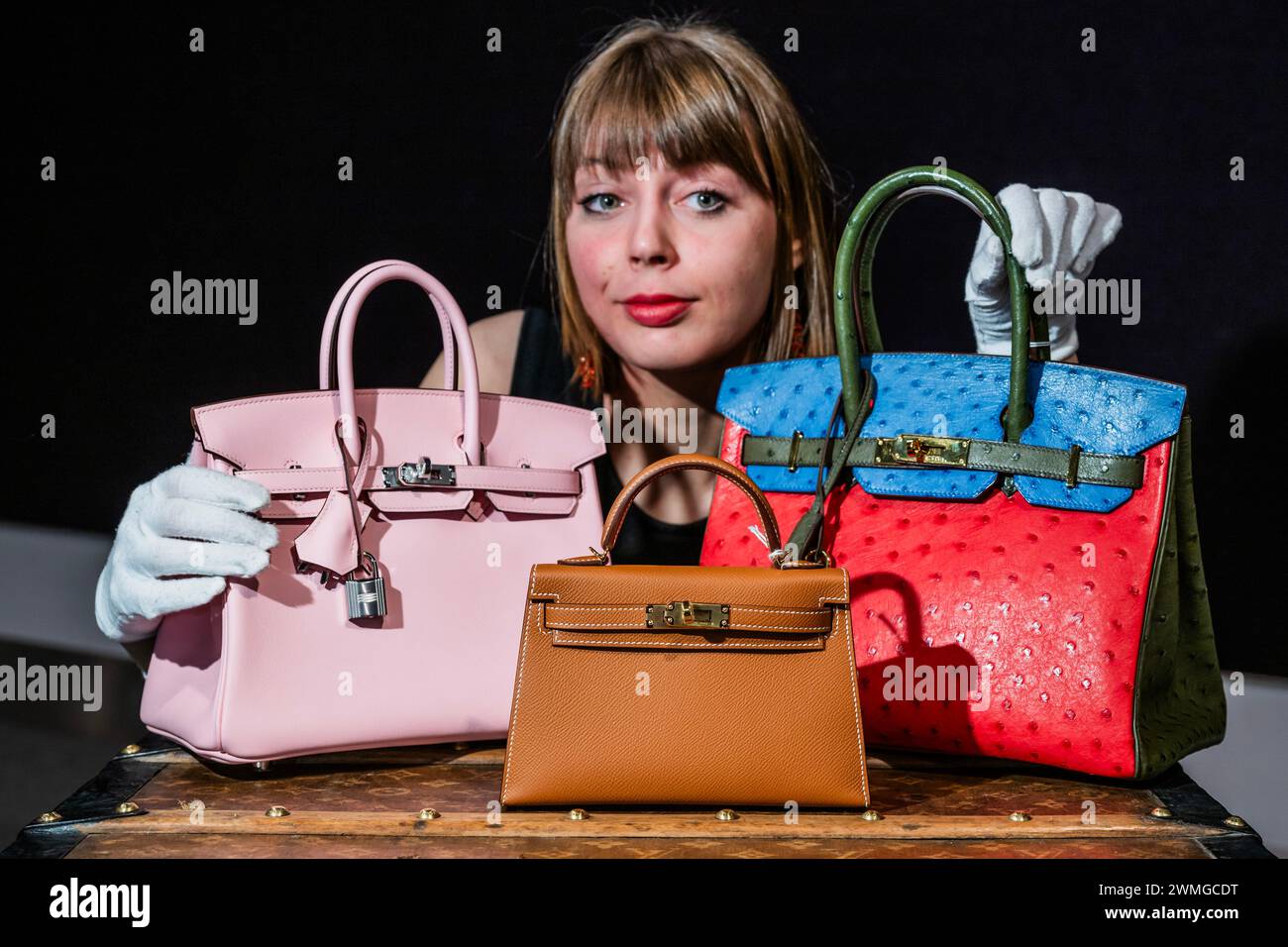London UK. 26th Feb 2024. Rose Sakura Swift Leather Birkin 25 with a Gold Epsom Leather Mini Kelly II 20 2023 and a Special Order Tri Colour Ostrich Birkin 30 all Hermes and