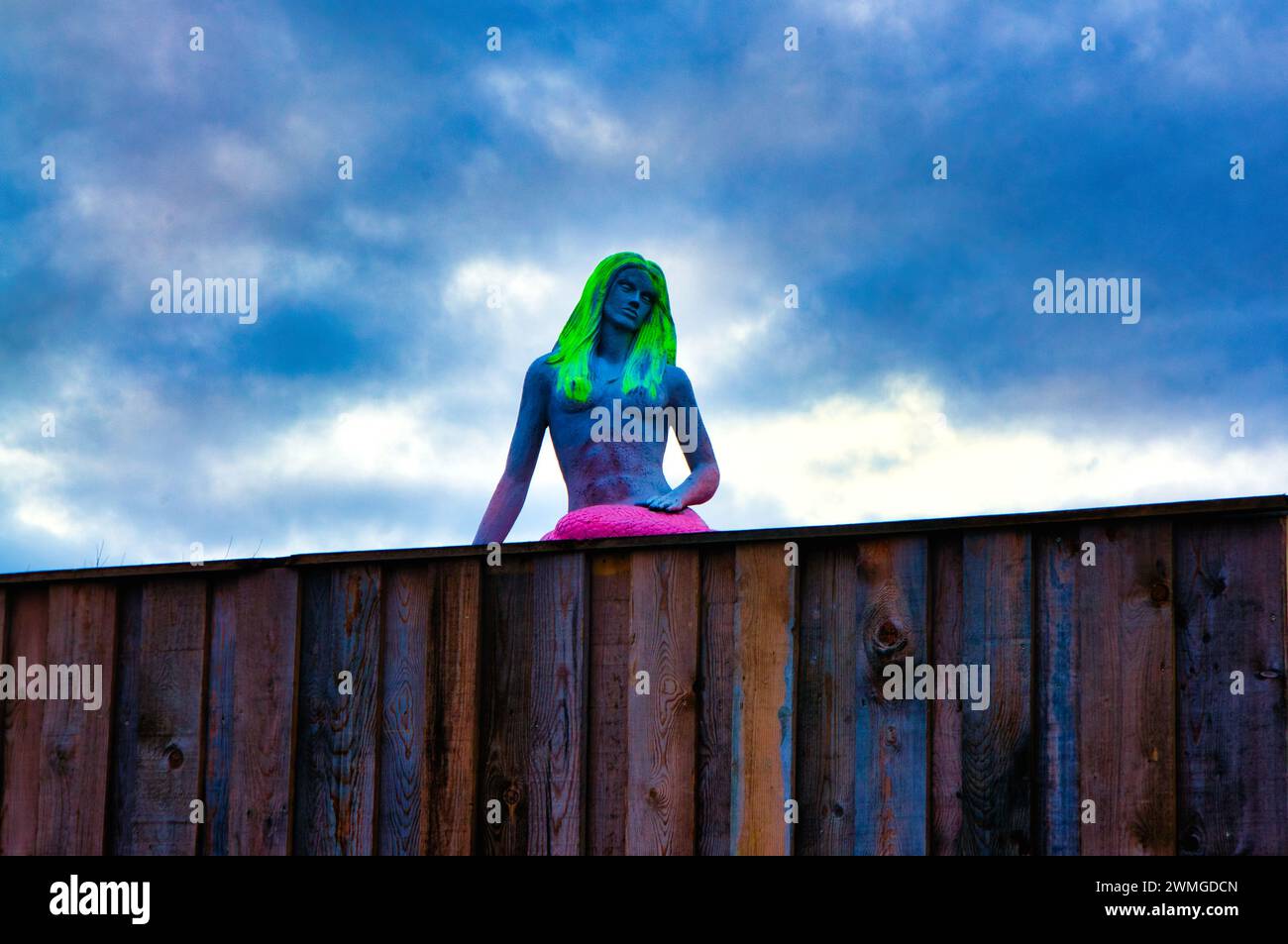 A sculpture of a woman with vibrant green hair under a cloudy sky in Jois, Austria Stock Photo