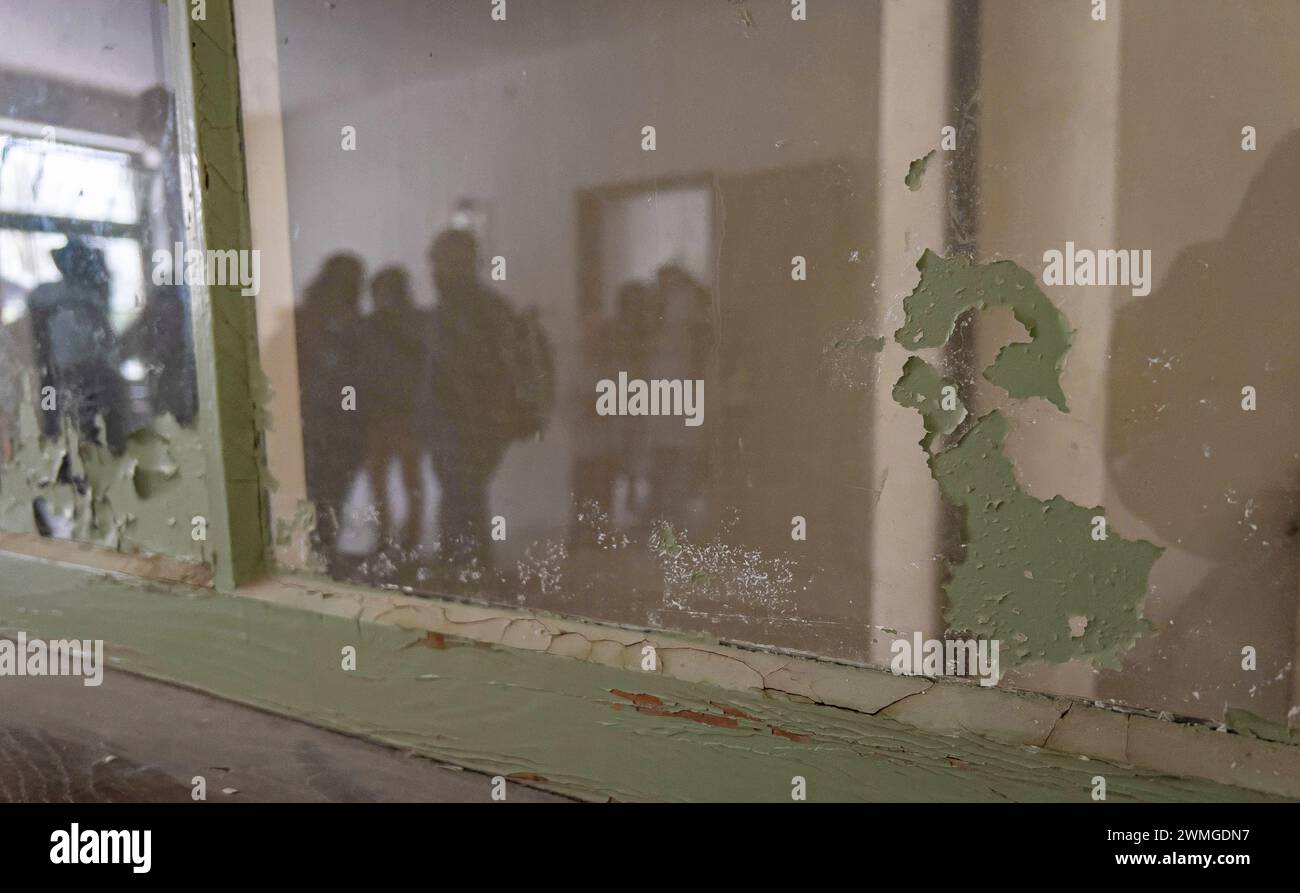 Blick durch ein verstaubtes Glas, an welchem die Farbe abblättert, in einem verschlossenen Raum in der Baracke X des ehemaligen Konzentrationslager Da Stock Photo