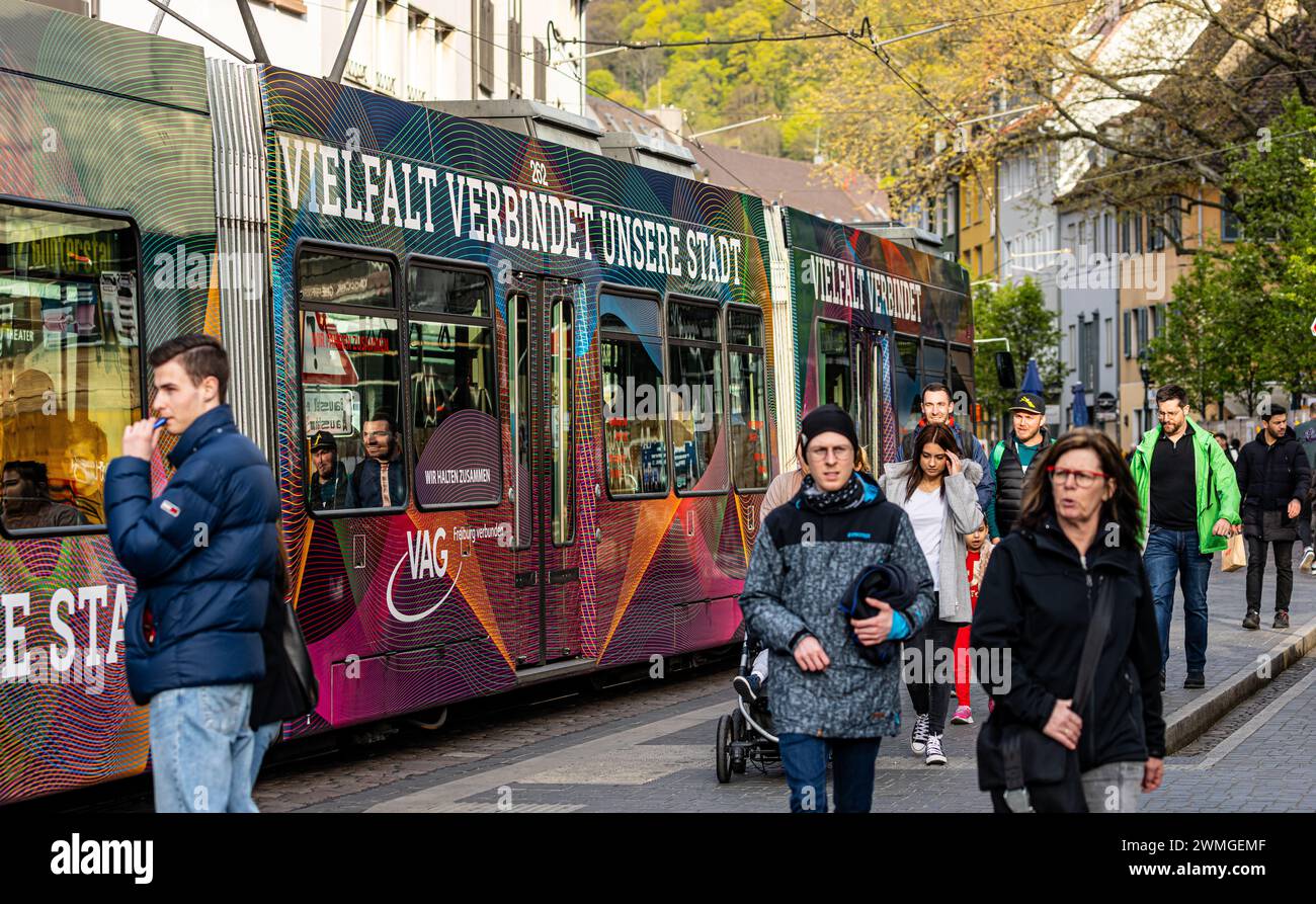Eine Strassenbahn mit der seitlichen Aufschrift 'Vielfalt verbindet unsere Stadt' fährt beim Platz der alten Synagoge vorbei. (Freiburg im Breisgau, D Stock Photo