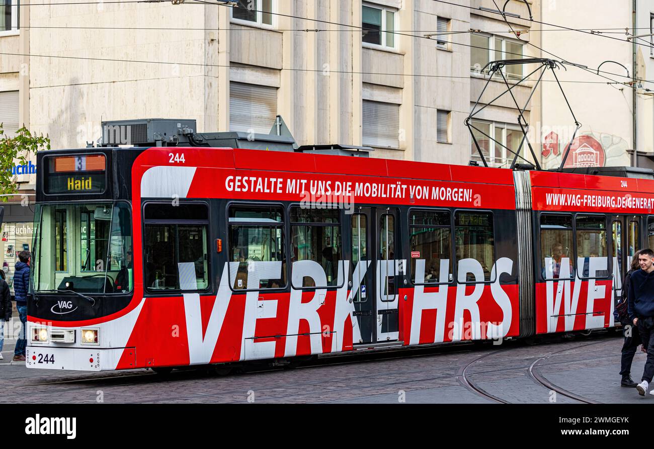 Eine Strassenbahn in Freiburg fährt am Platz der alten Synagoge vorbei. Auf der Seite sind verschiedene Mobilitätsformen zu finden. (Freiburg im Breis Stock Photo