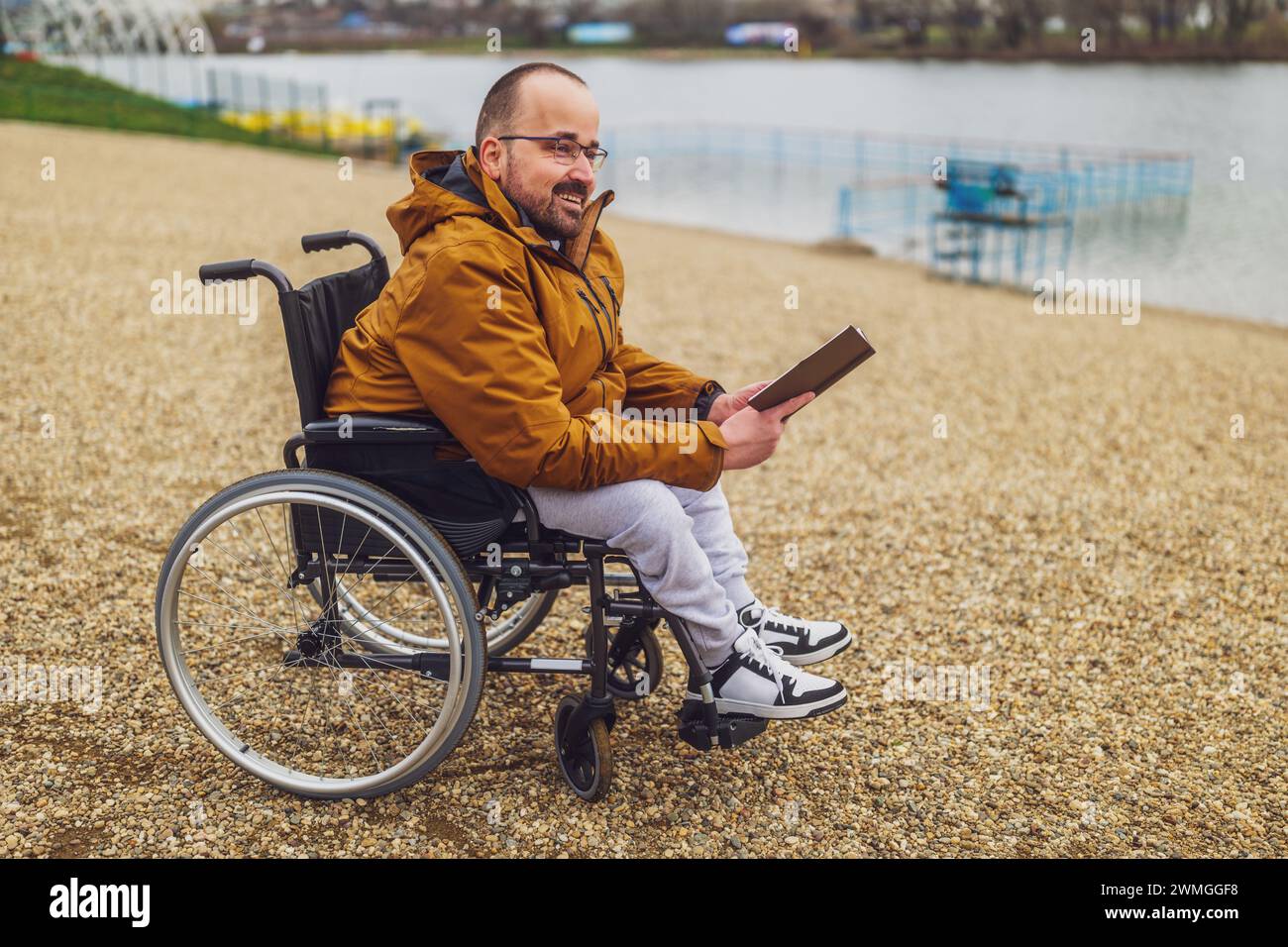 Paraplegic handicapped man in wheelchair is reading book outdoor Stock ...