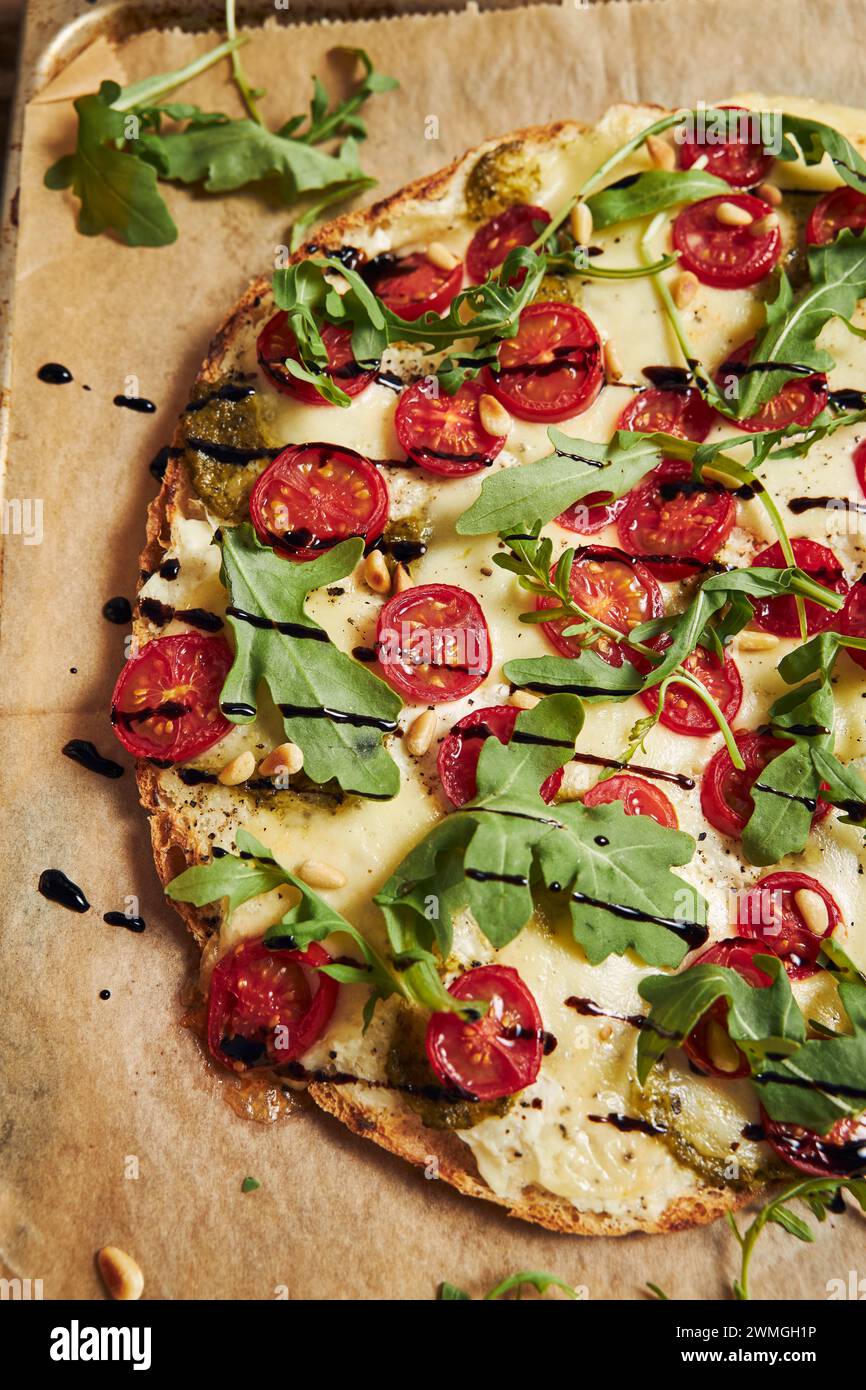 A freshly baked delicious pizza with tomato-mozzarella and arugula Stock Photo