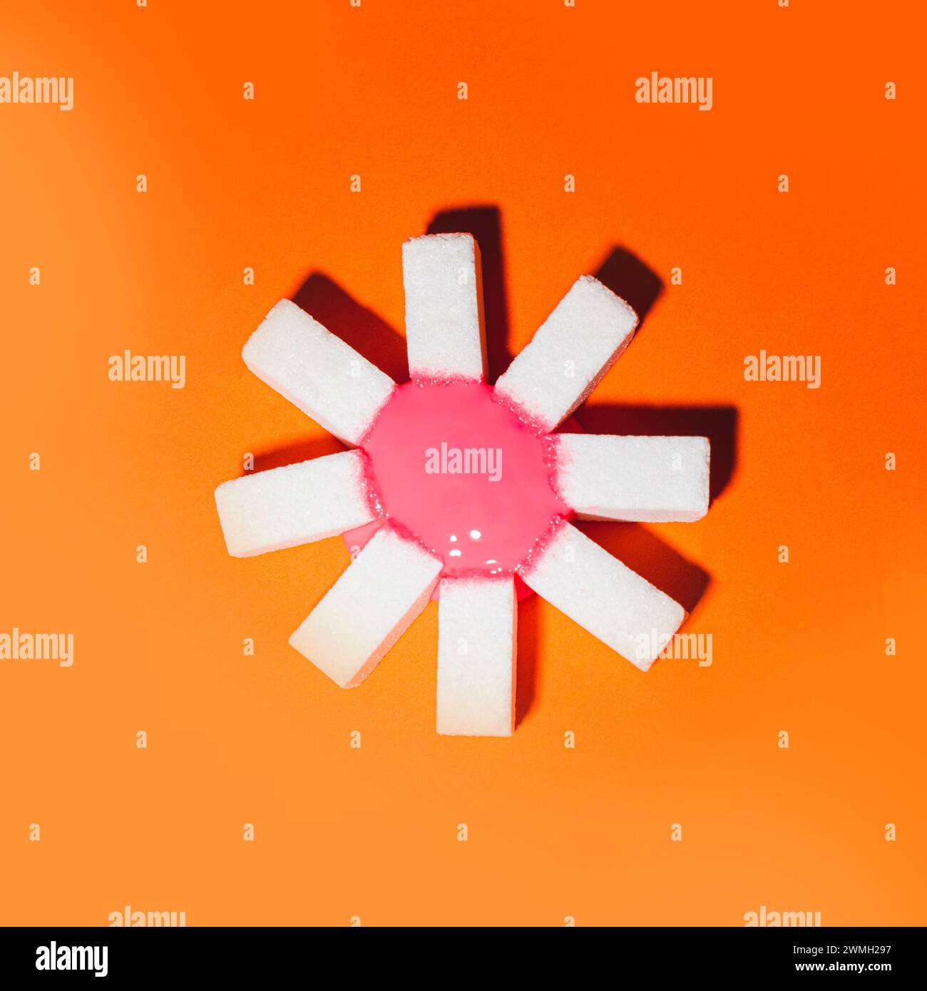 top view of white sugar cubes with red circle on orange background with copy space Stock Photo