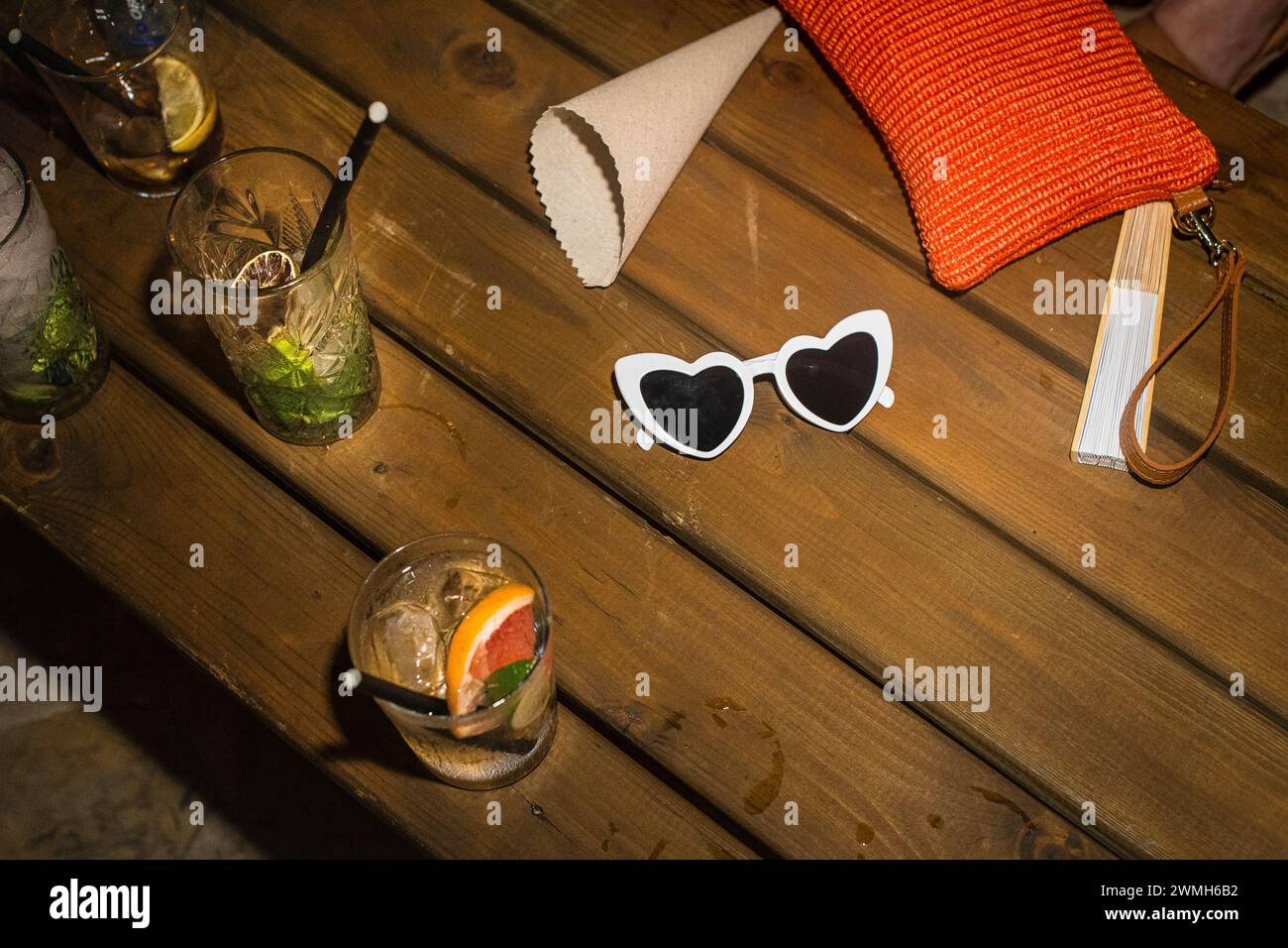 Heart shaped Sunglasses and drinks on bench Stock Photo