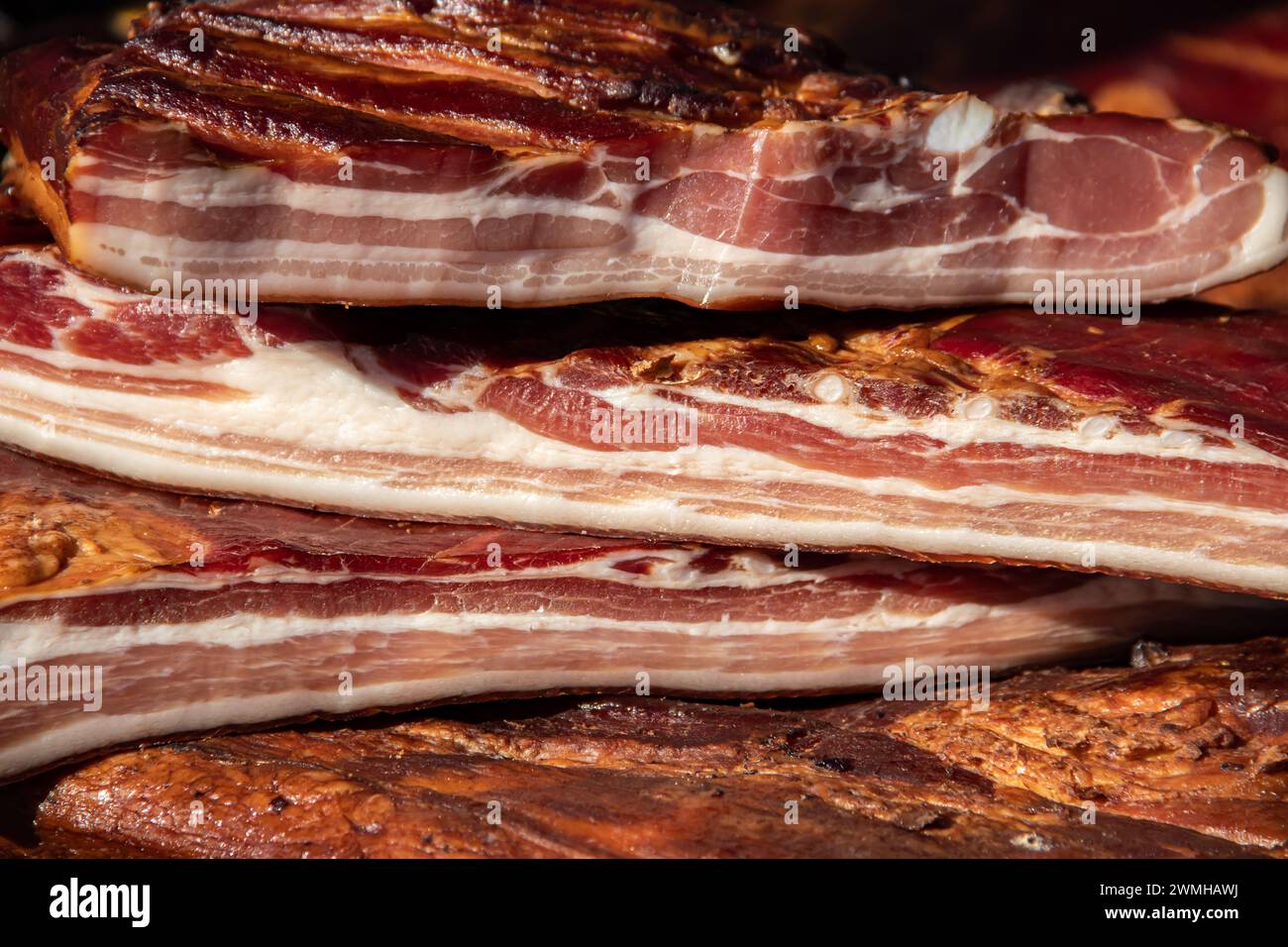 Exposed bacon and dried meat domestic products presented for sale on a farmer's market in Kacarevo village, gastro bacon and dry meat products Stock Photo