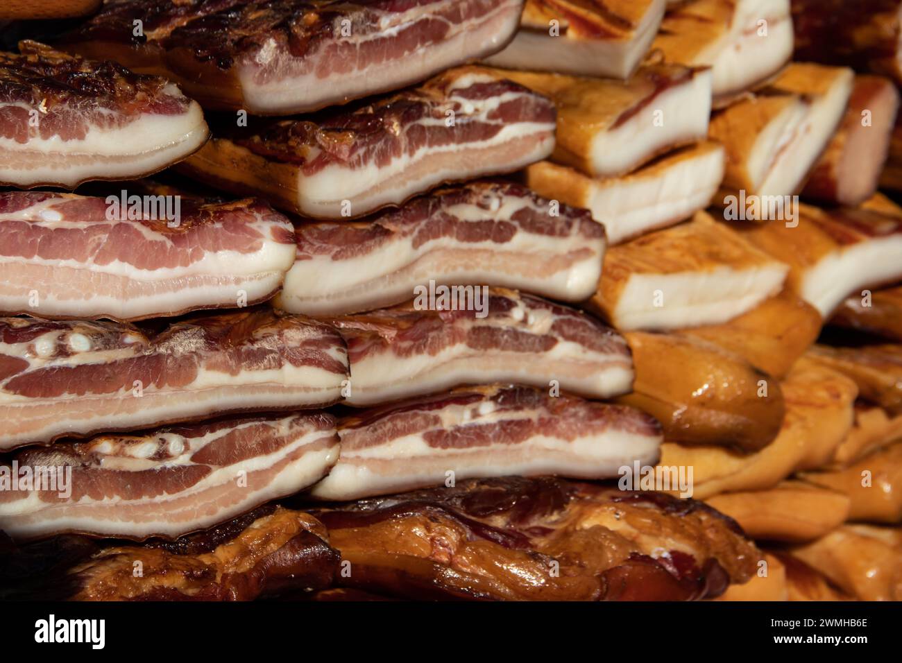 Exposed bacon and dried meat domestic products presented for sale on a farmer's market in Kacarevo village, gastro bacon and dry meat products Stock Photo