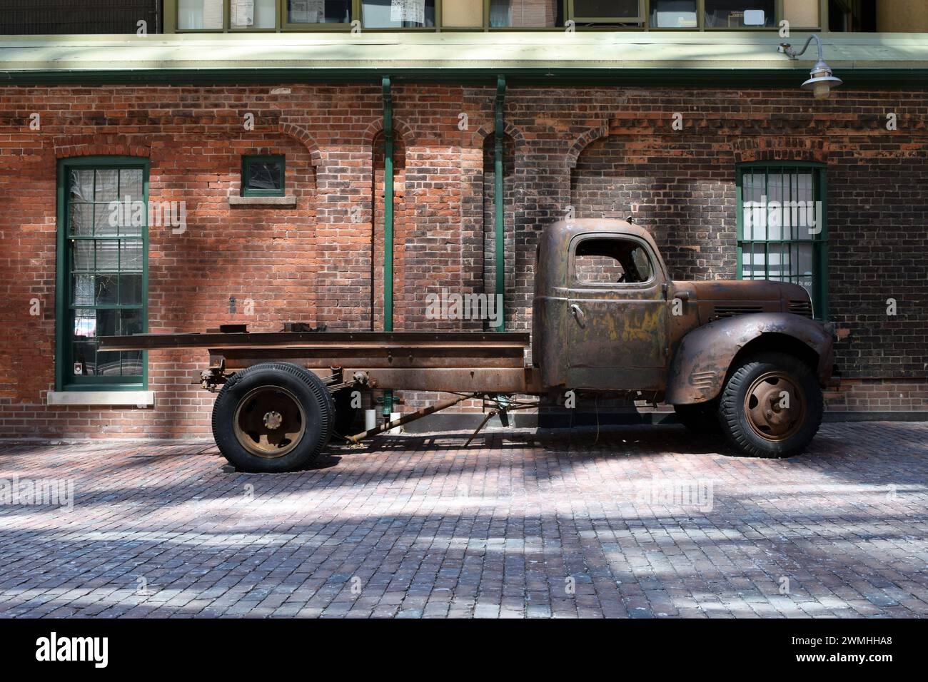Rusty Vintage 1940s American Dodge Flatbed Truck next to a Brick Wall in the Historic Distillery District, Toronto, Ontario, Canada Stock Photo