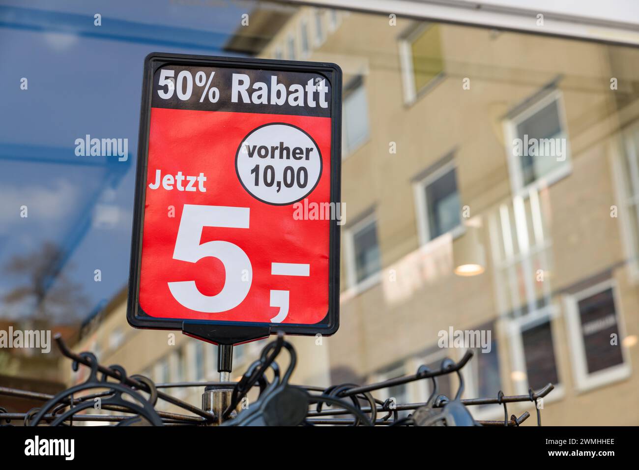 A display with 50% off discount stands outside in front of a fashion store in Germany. Stock Photo