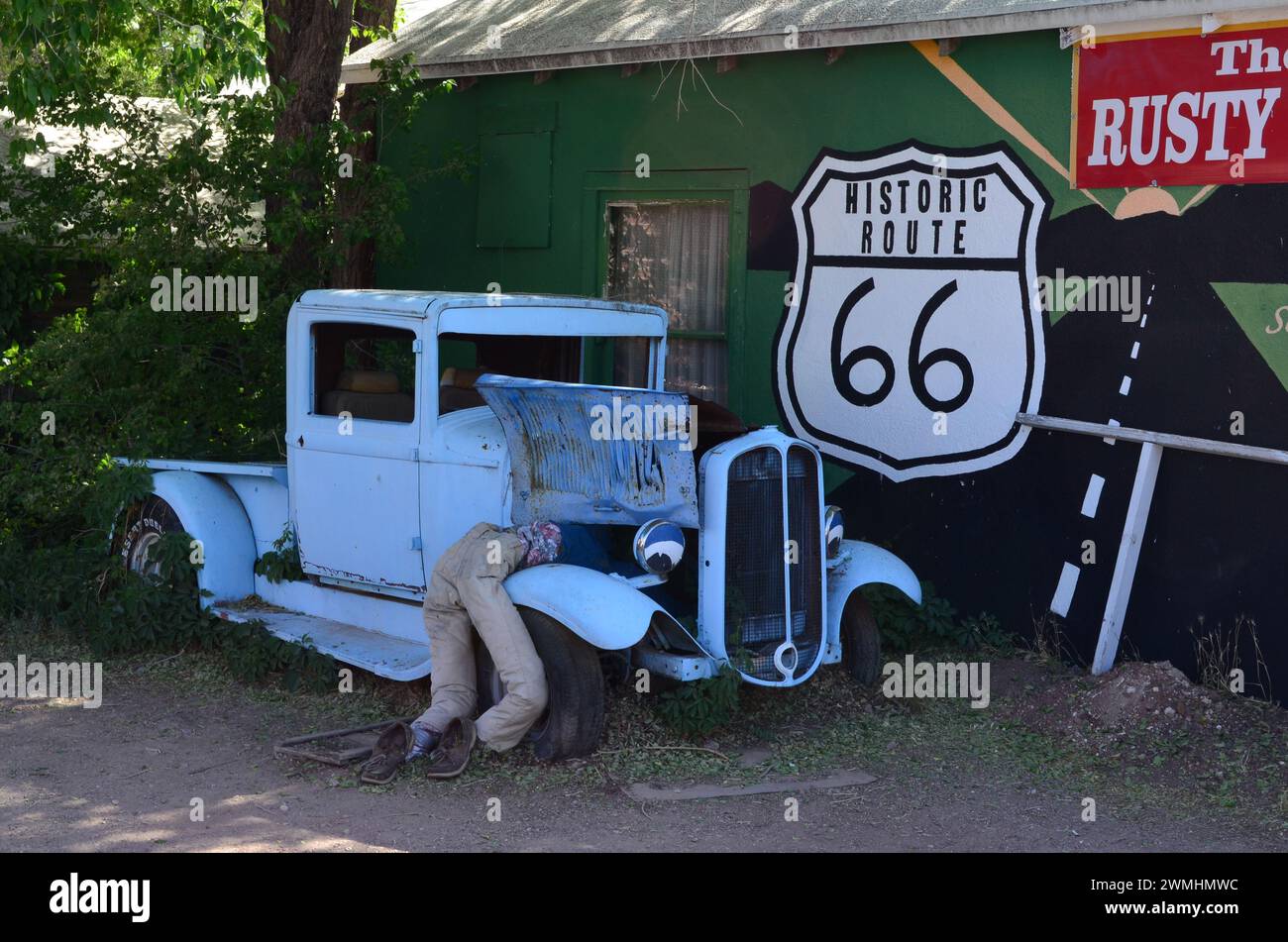 Light Blue 1932 Ford Model B Pickup Truck & Dummy Mechanic's Legs Sticking Out and Route 66 Sign on Roadside, Route 66, Seligman, Arizona, USA Stock Photo