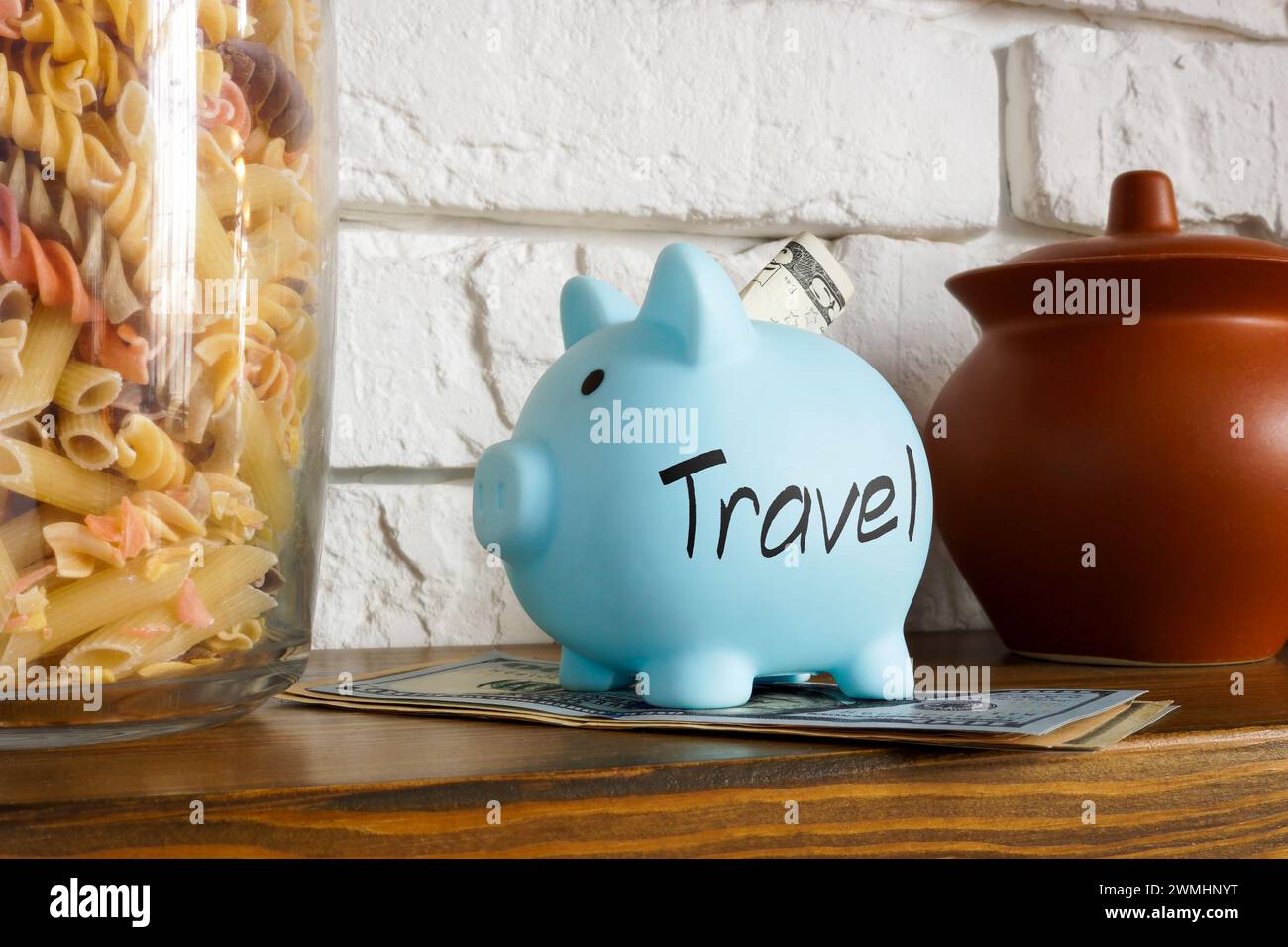 Savings for travel concept. Piggy bank on shelf at home. Stock Photo