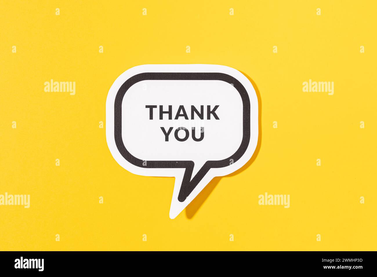 Thank you text on speech bubble isolated on yellow background Stock Photo