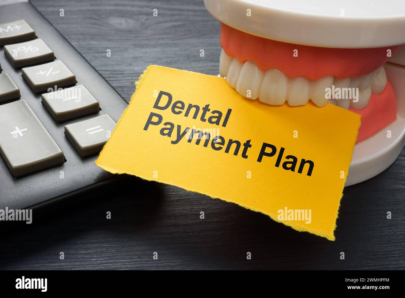 dental-payment-plan-calculator-and-jaws-holding-a-sheet-stock-photo
