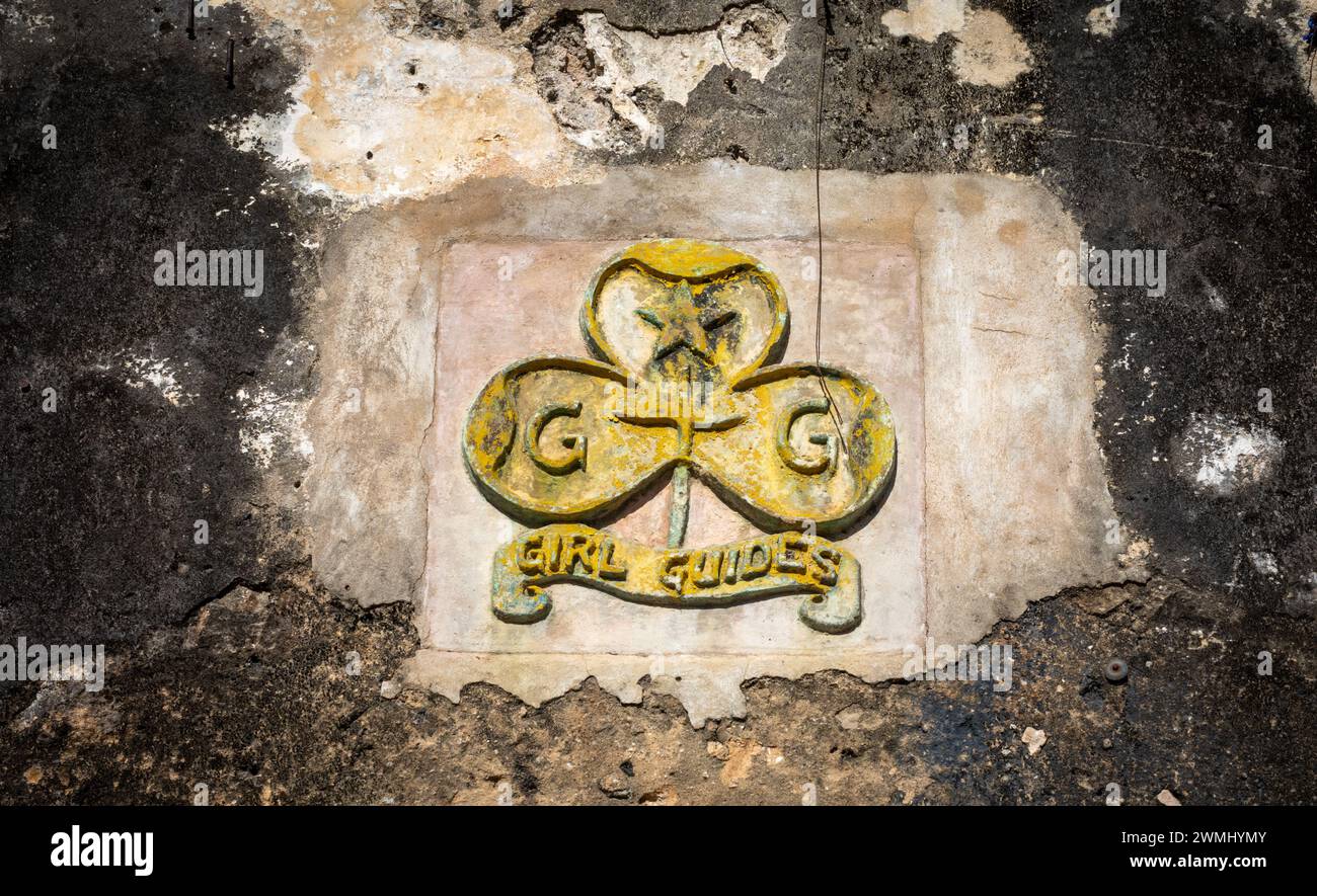 A very old concrete bas-relief crest badge for the Girl Guides above a doorway into the old fort in Stone Town, Zanzibar, Tanzania. Stock Photo