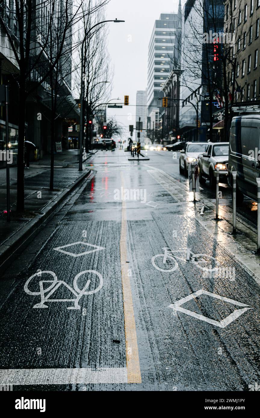 A photo of the two-way bike lane on Dunsmuir Street, at the intersection with Granville Street, on a rainy day, showing the bicycle and diamond signs. Stock Photo