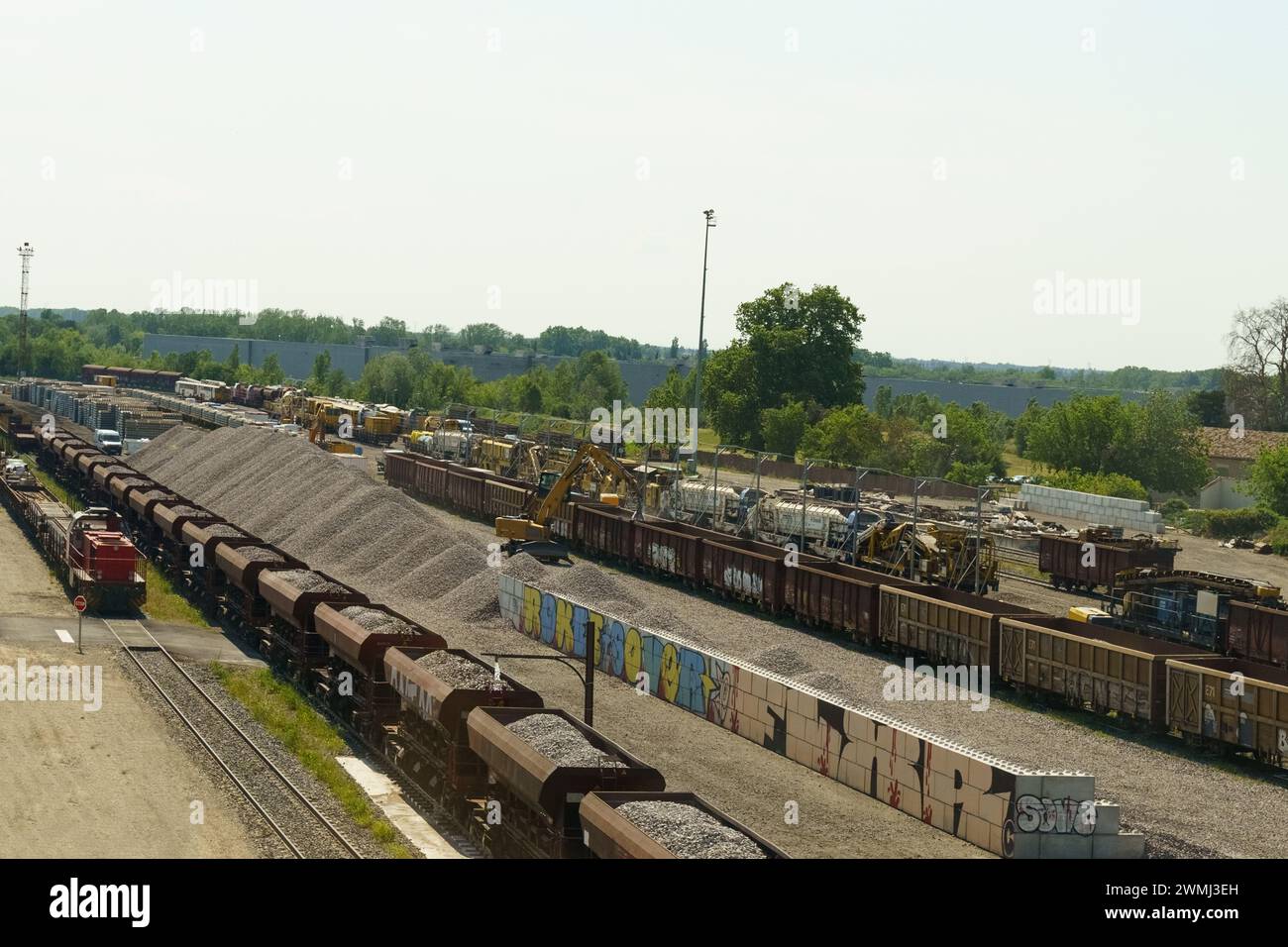 Lyon, France - May 16, 2023: Multiple rows of freight trains are loaded with various goods at a sprawling train yard. The day is clear and sunny, show Stock Photo