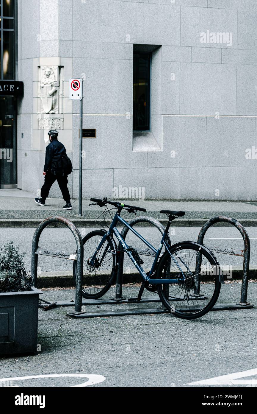 Vancouver, Canada - Feb 15 2024: A bicycle parked on Hornby Street, with its rider having just crossed the street. Stock Photo
