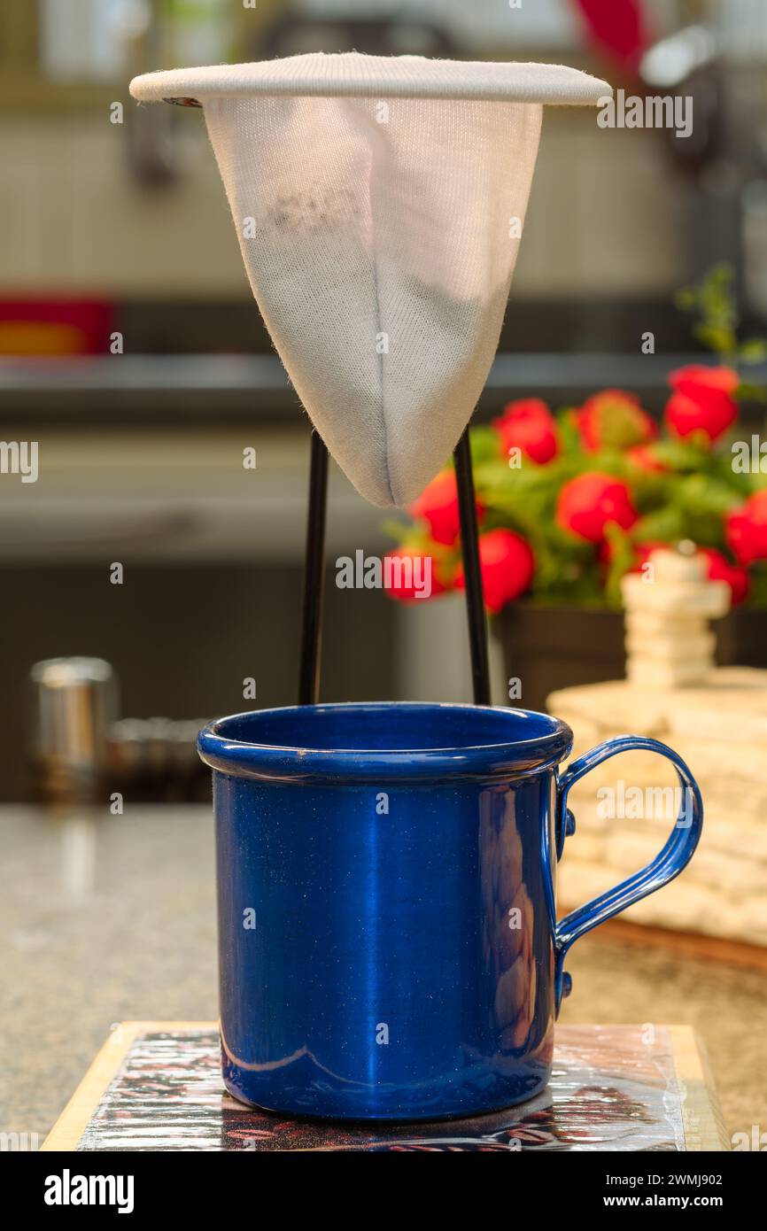 Cup of coffee under a cloth coffee strainer, individual portion Stock
