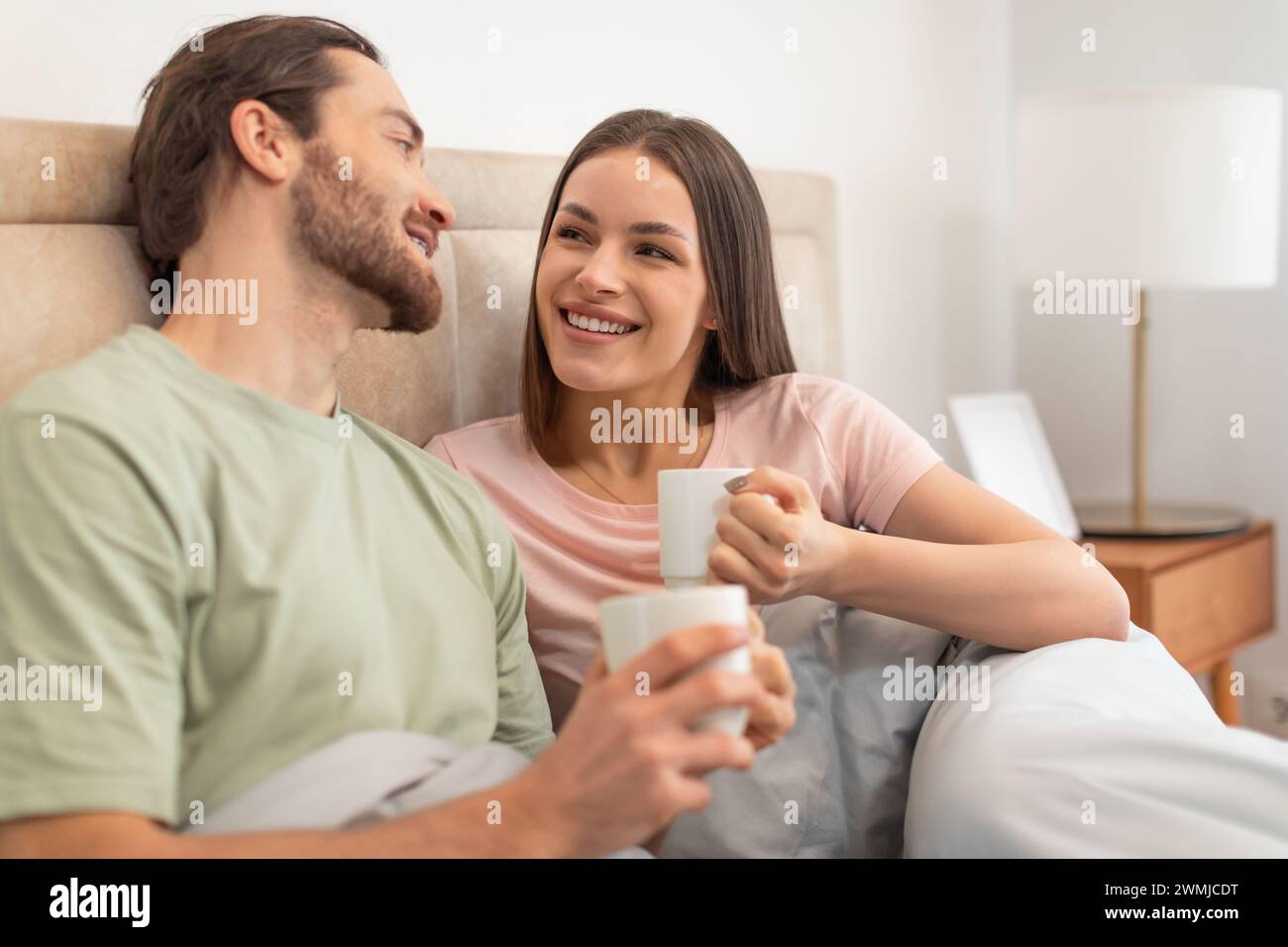 Happy couple enjoying coffee in bed, relaxed morning Stock Photo