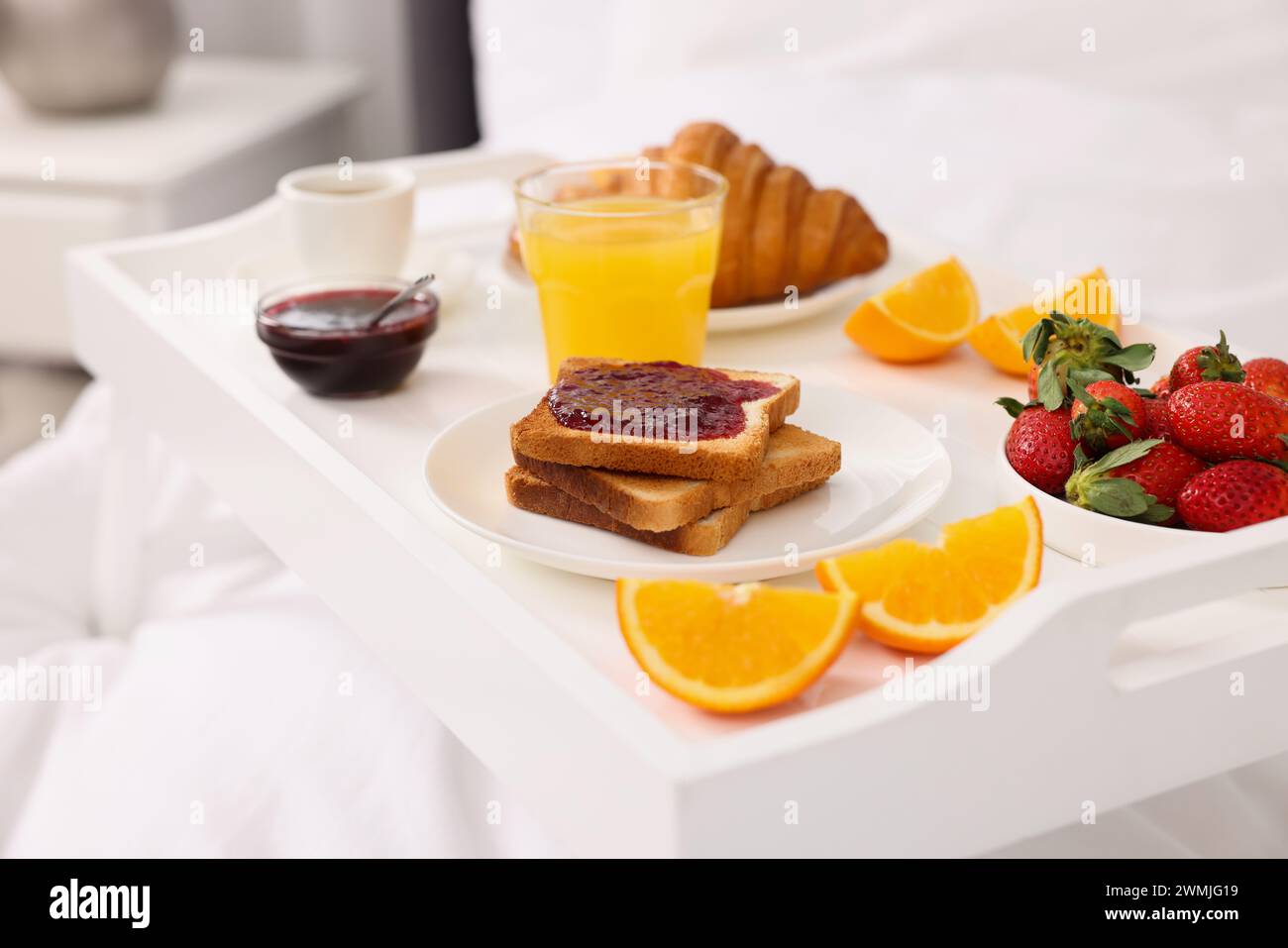 Tray with delicious breakfast on bed, closeup Stock Photo