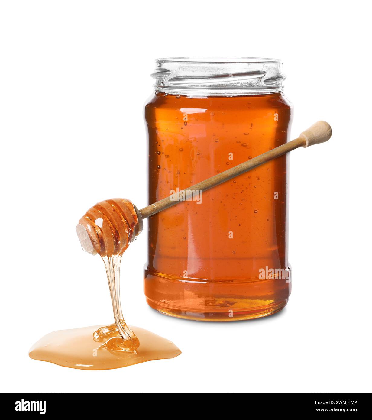 Natural honey dripping from dipper. Jar full of honey on white ...