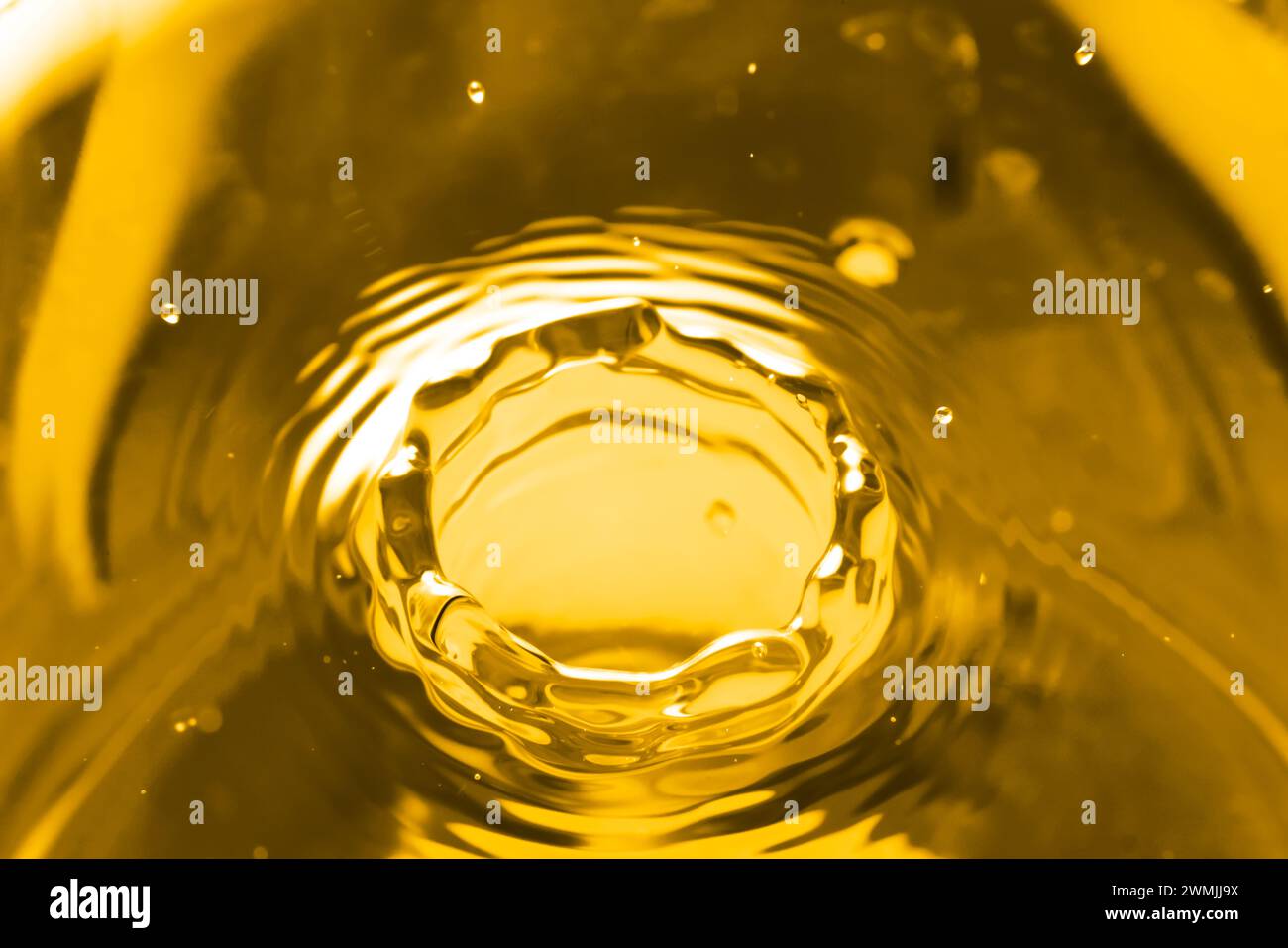 Splash of golden oily liquid as background, closeup Stock Photo - Alamy