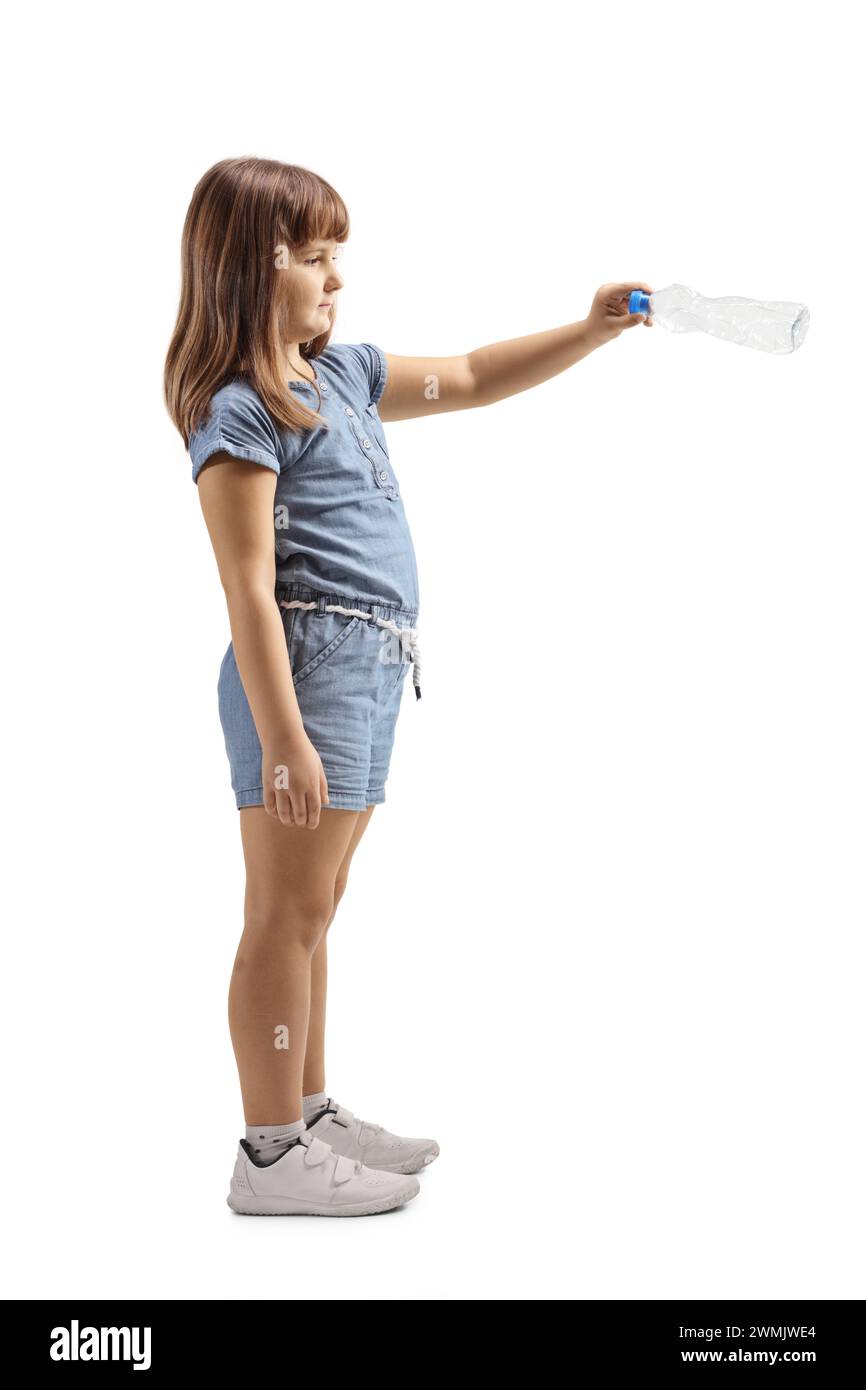 Full length profile shot of a little girl throwing a plastic bottle isolated on white background Stock Photo