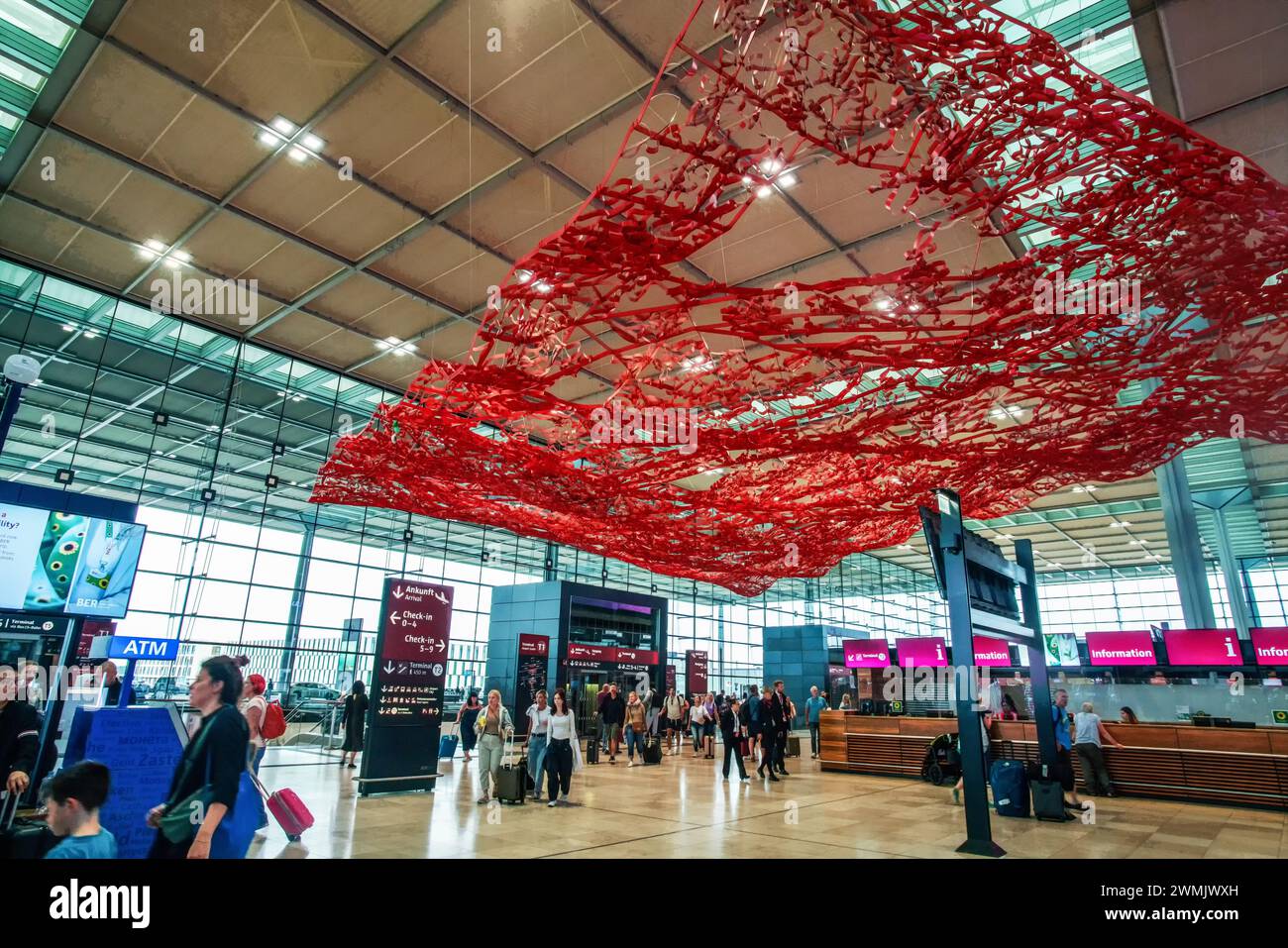 08-27-2023  Berlin GERM  Space Great space of  Interior of  Berlin Brandenburg Airport  and people moving. Some red decoration Stock Photo